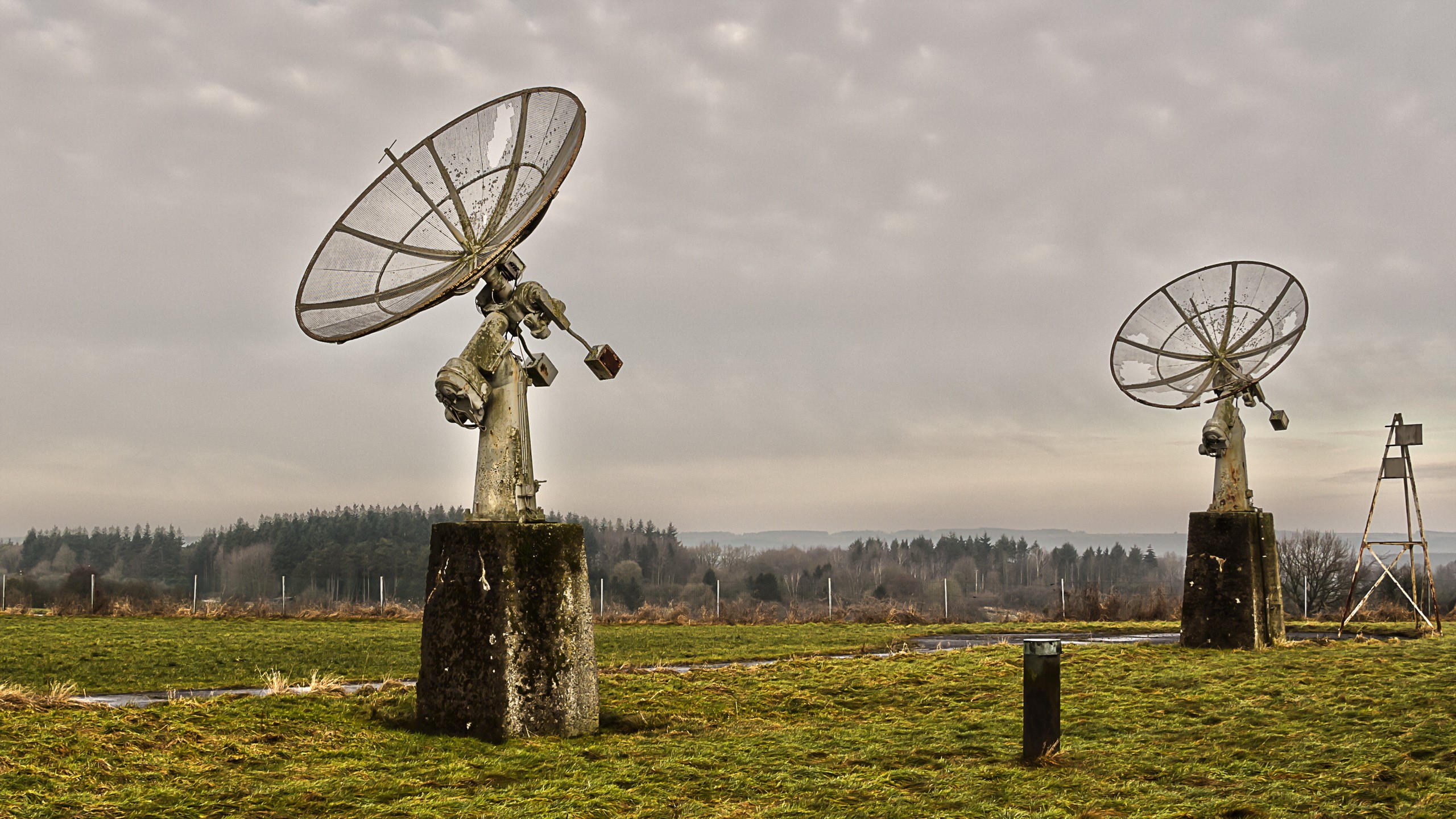 Two old satellite dishes in a field HD Wallpaper