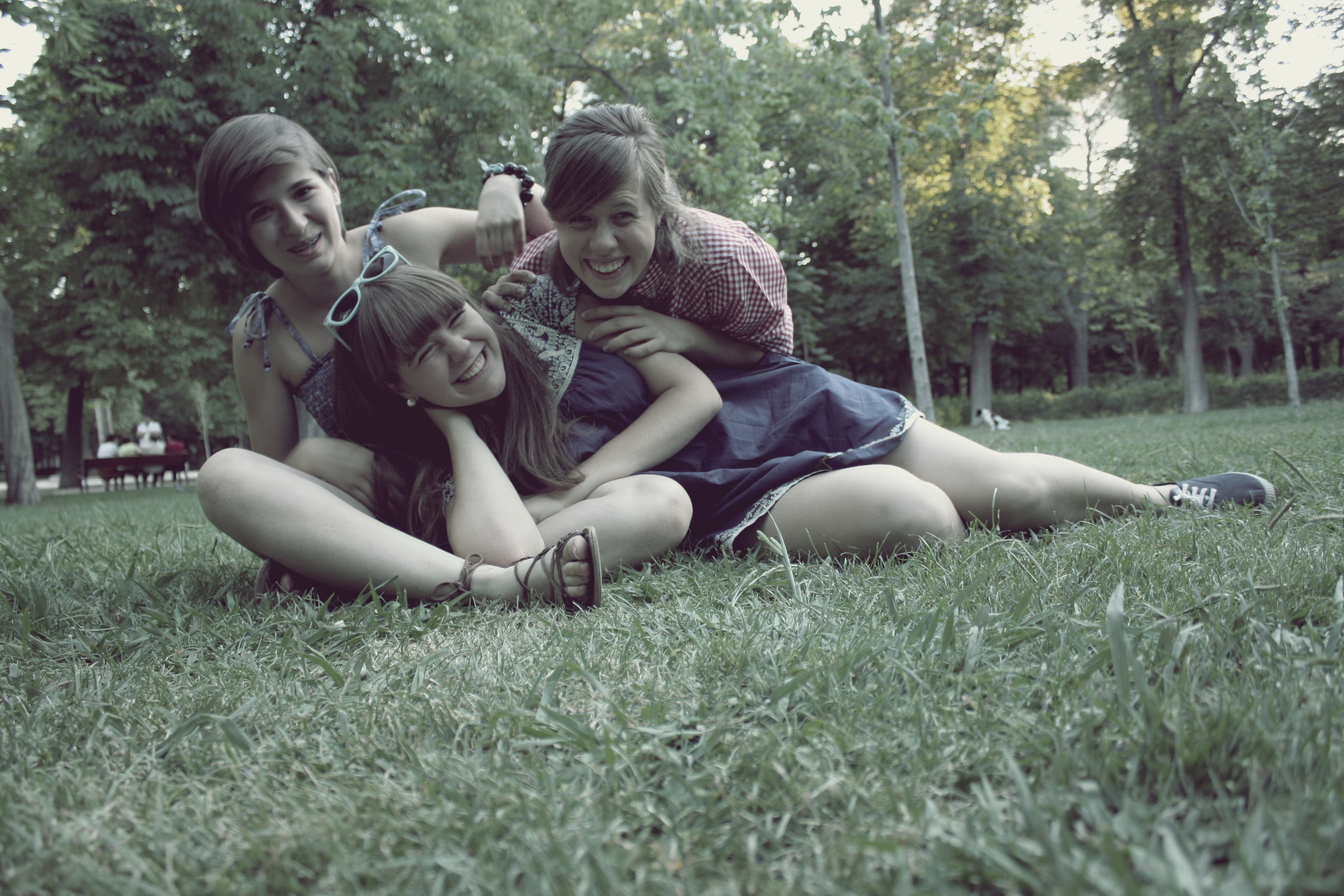 Three smiling girls sitting on grass HD Wallpaper