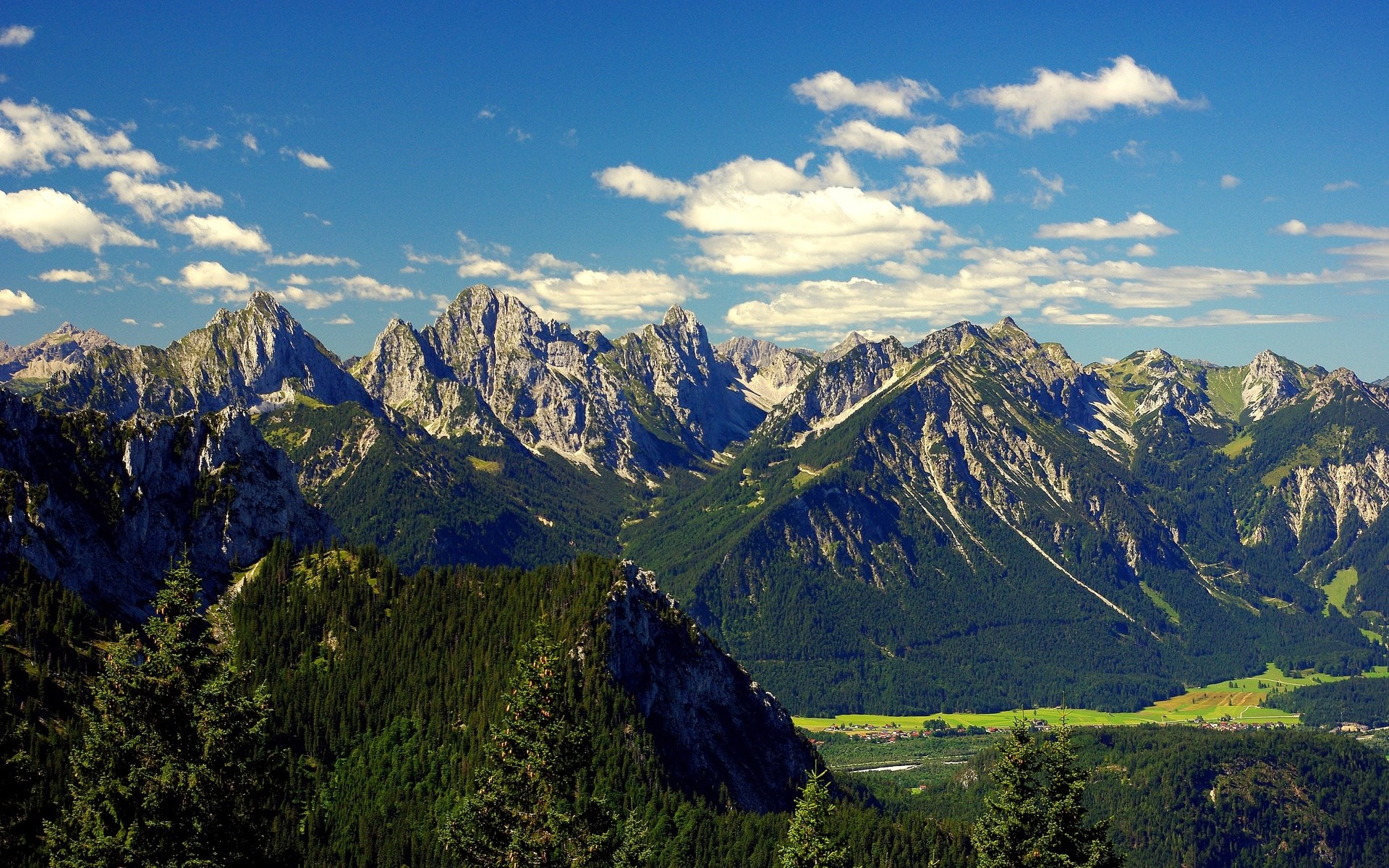 Jagged mountain range under a blue sky with clouds HD Wallpaper