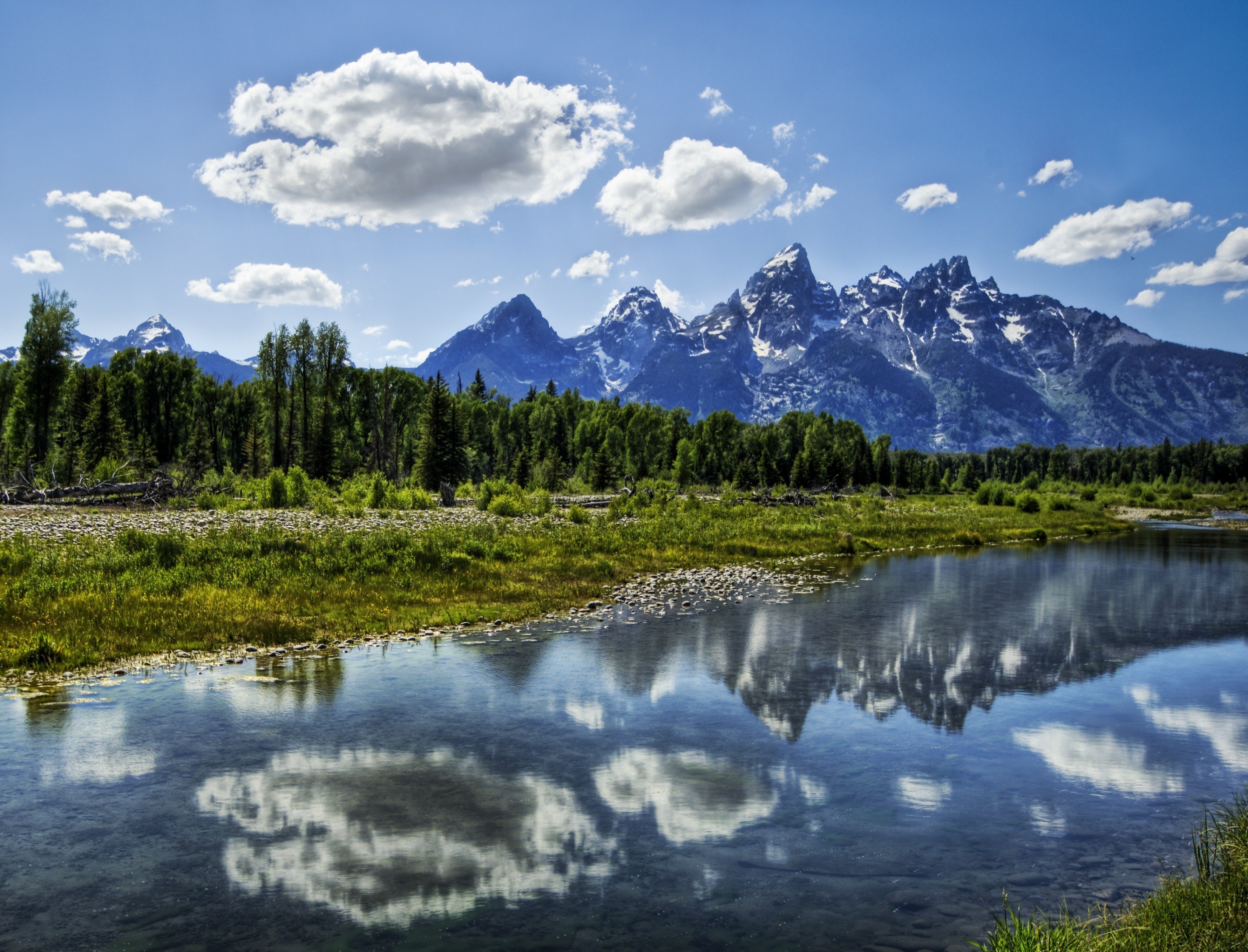 Mountains reflected in a river under a cloudy sky HD Wallpaper