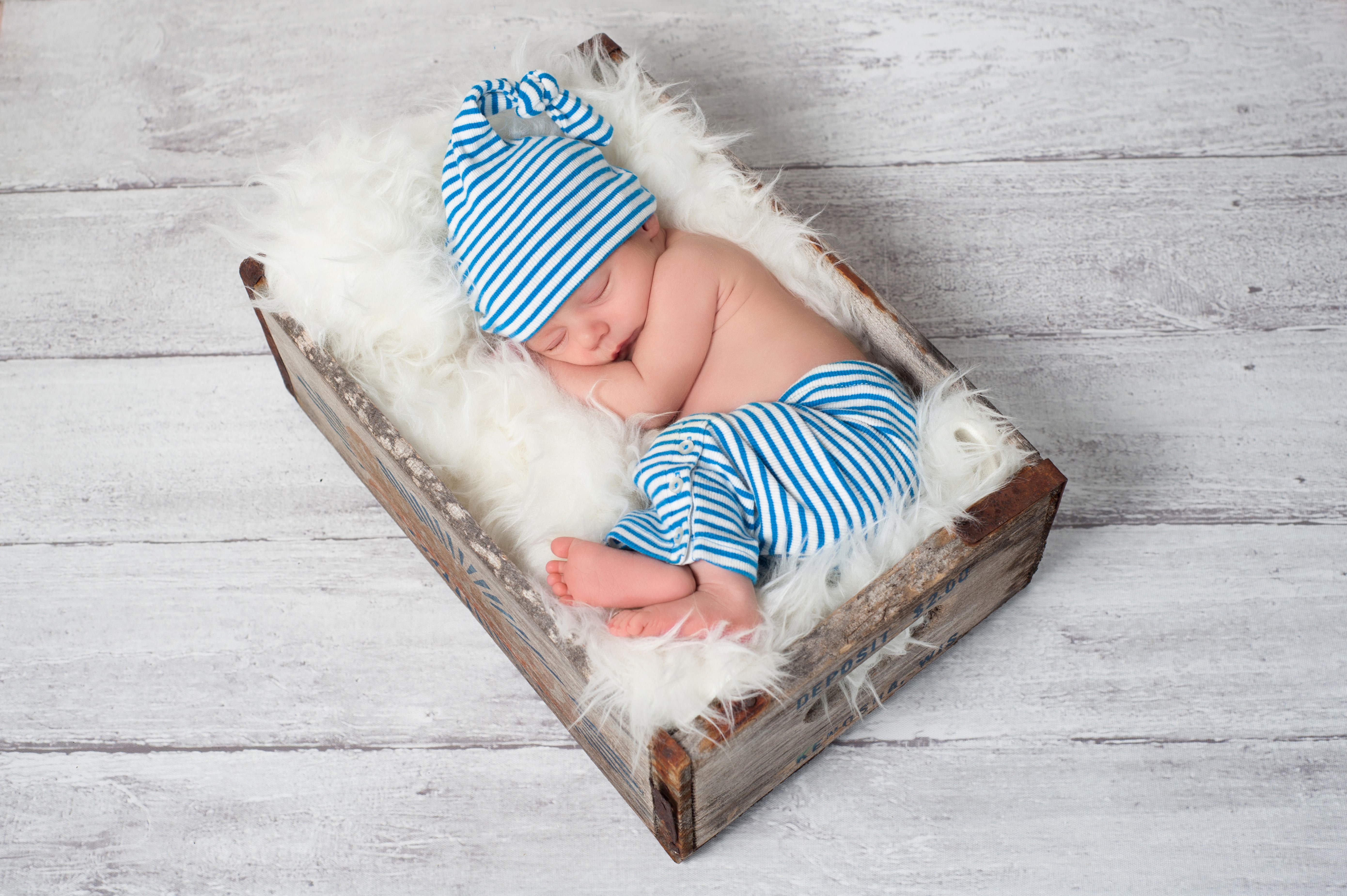 Newborn baby sleeping in a wooden crate HD Wallpaper