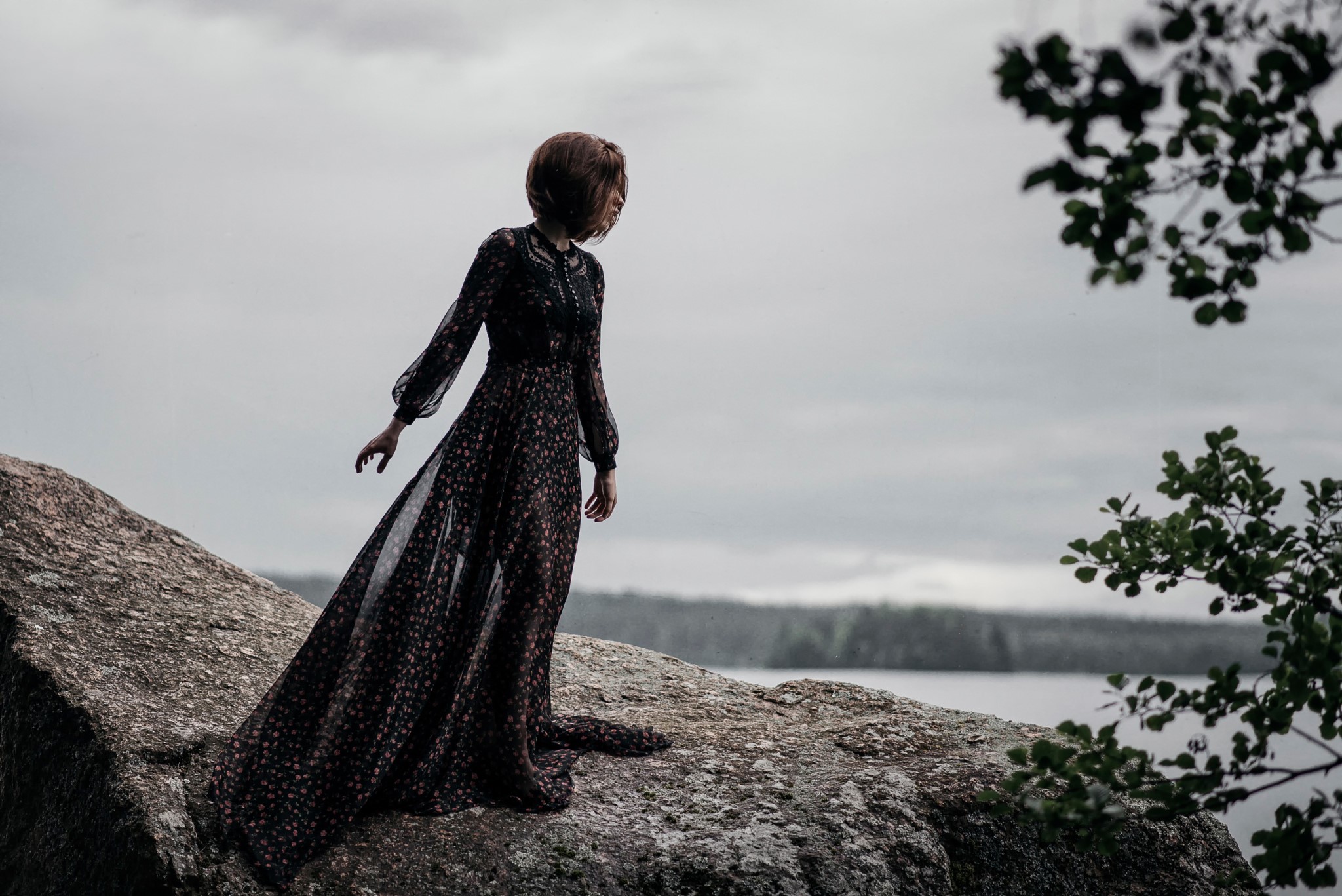 Woman in a floral dress on a rock by the water HD Wallpaper