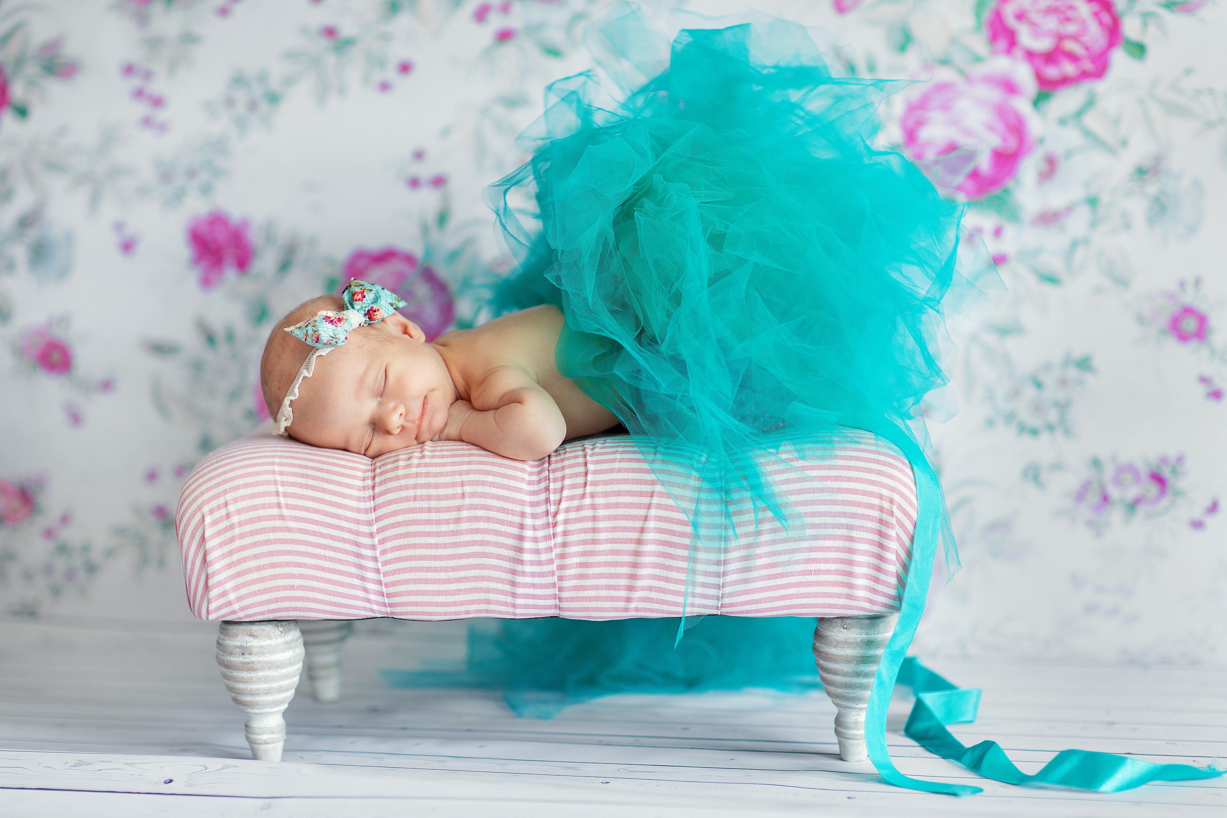 Newborn baby sleeping on a bench with a turquoise tutu HD Wallpaper