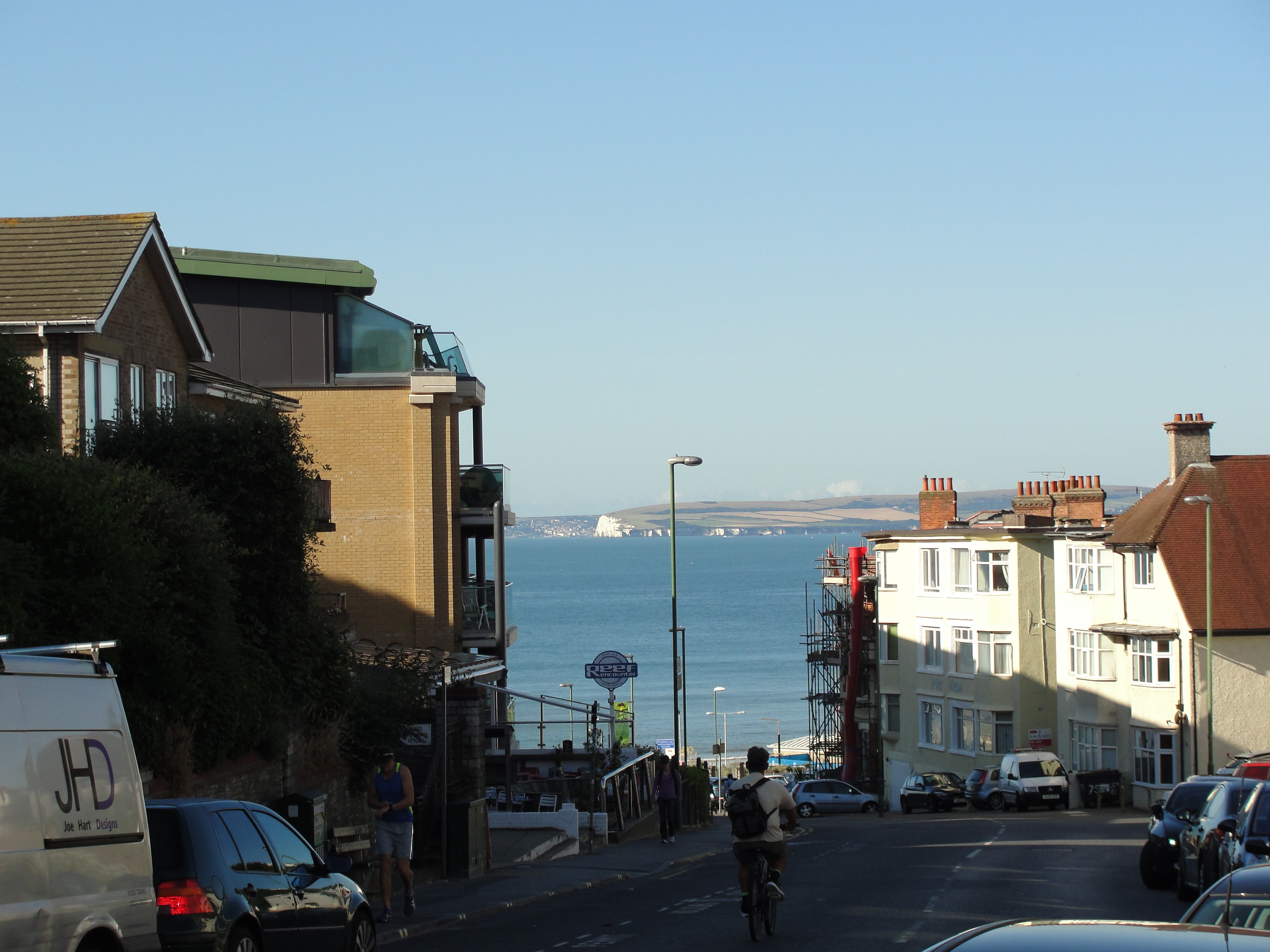 Street view of Bournemouth with the sea and cliffs in the background HD Wallpaper
