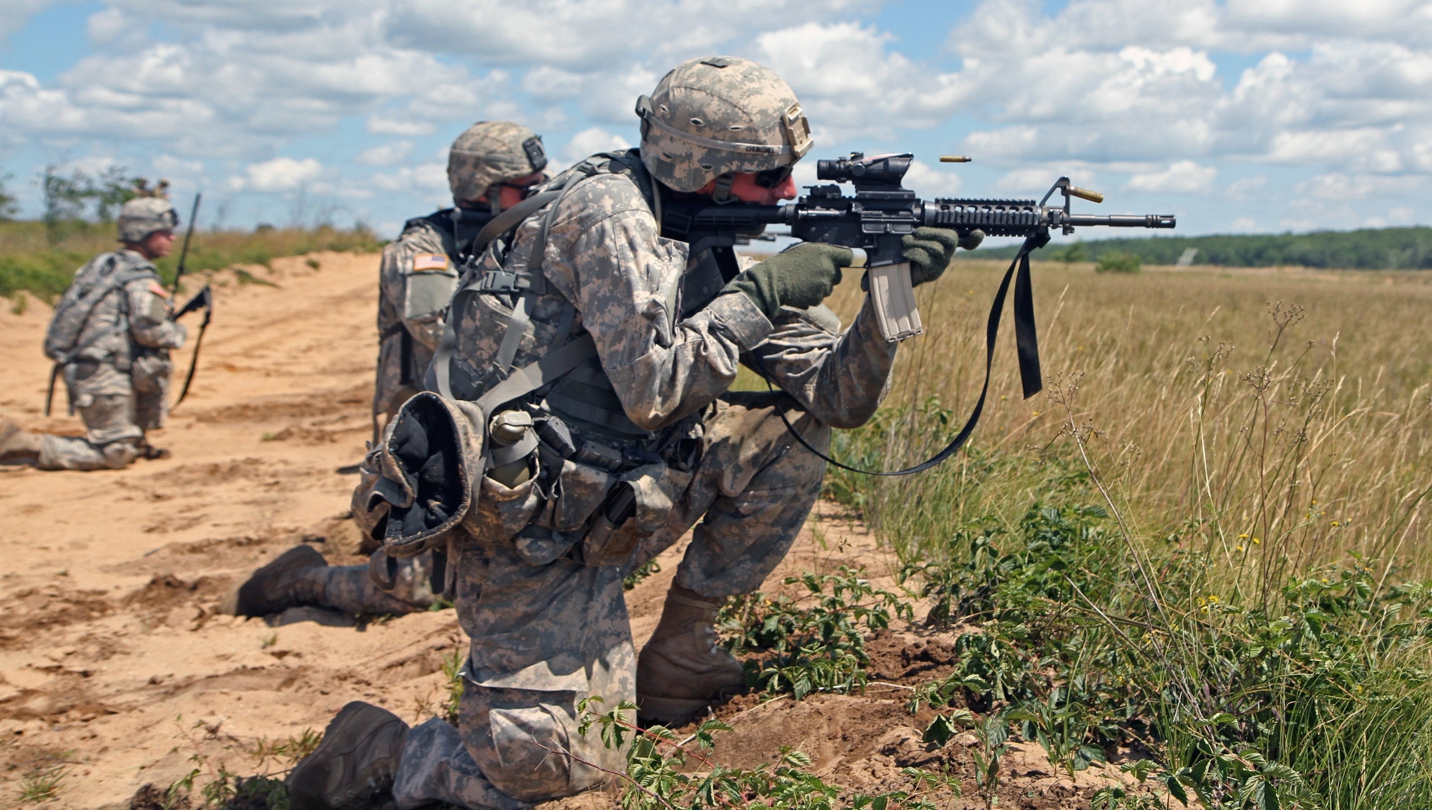 Soldiers firing assault rifles in a field HD Wallpaper
