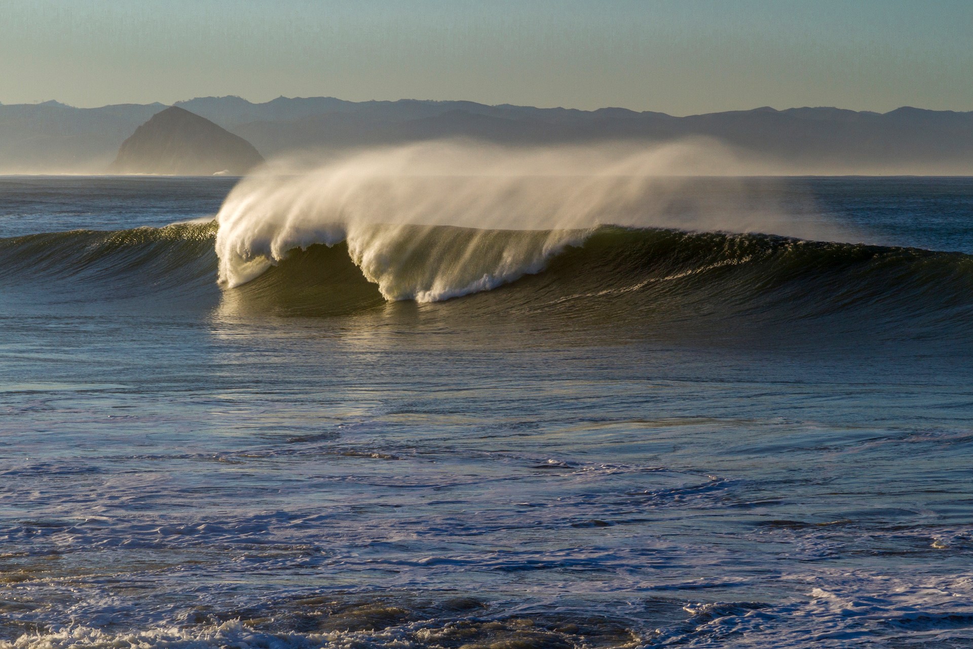 Ocean wave breaking with spray in the air HD Wallpaper