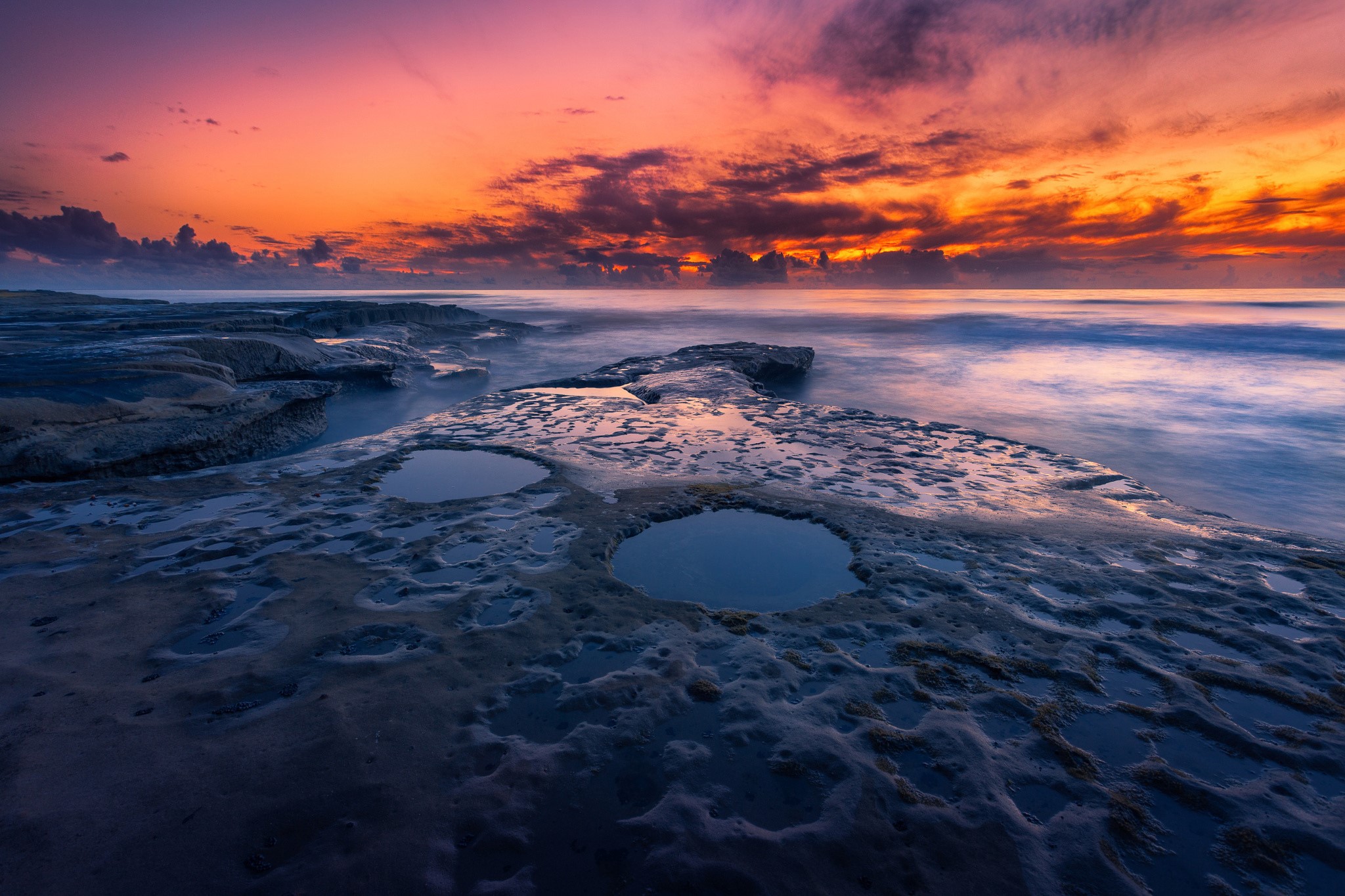 Sunset over the ocean with rocky shore and tide pools HD Wallpaper