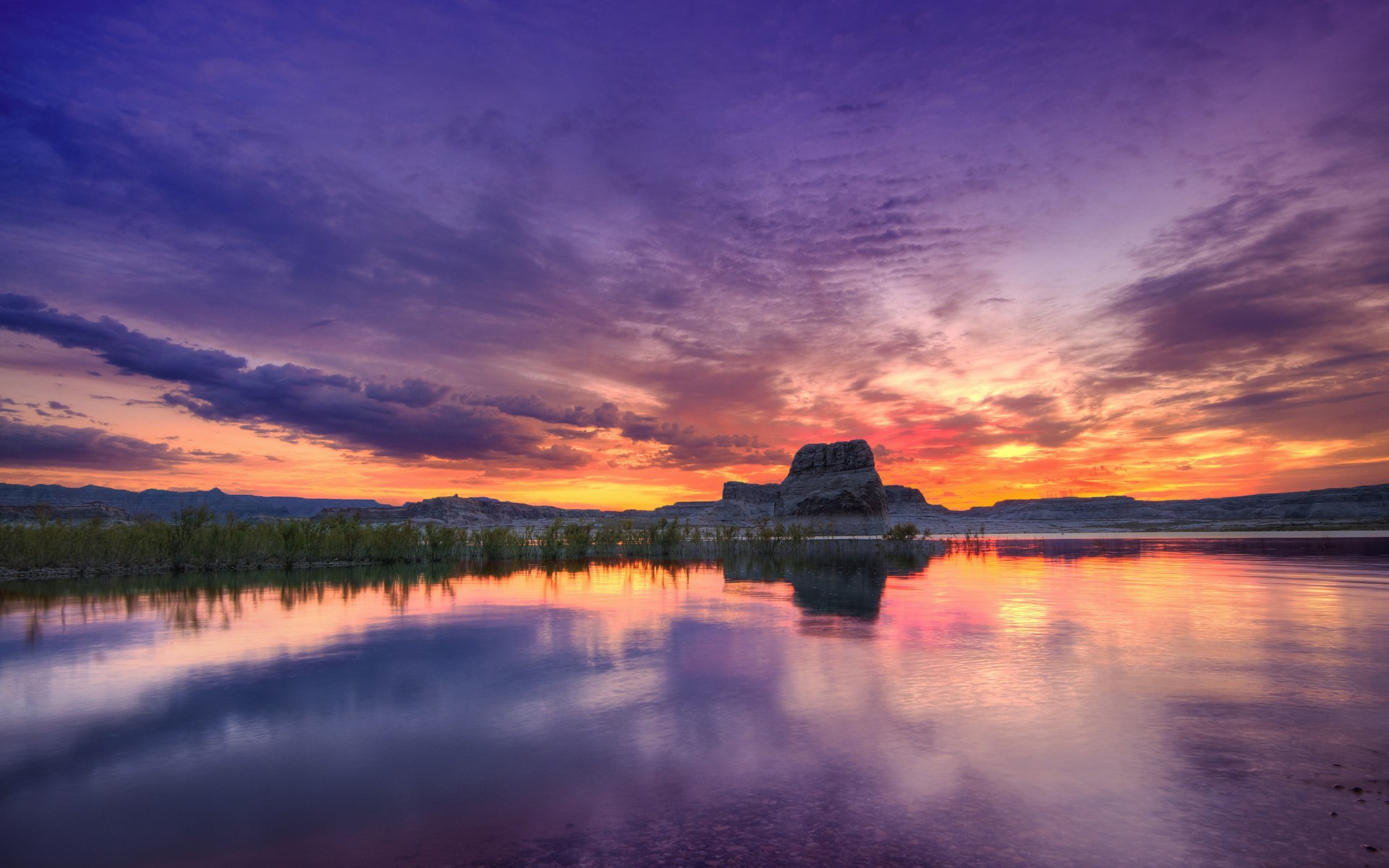 Sunset over a calm lake with rock formations HD Wallpaper