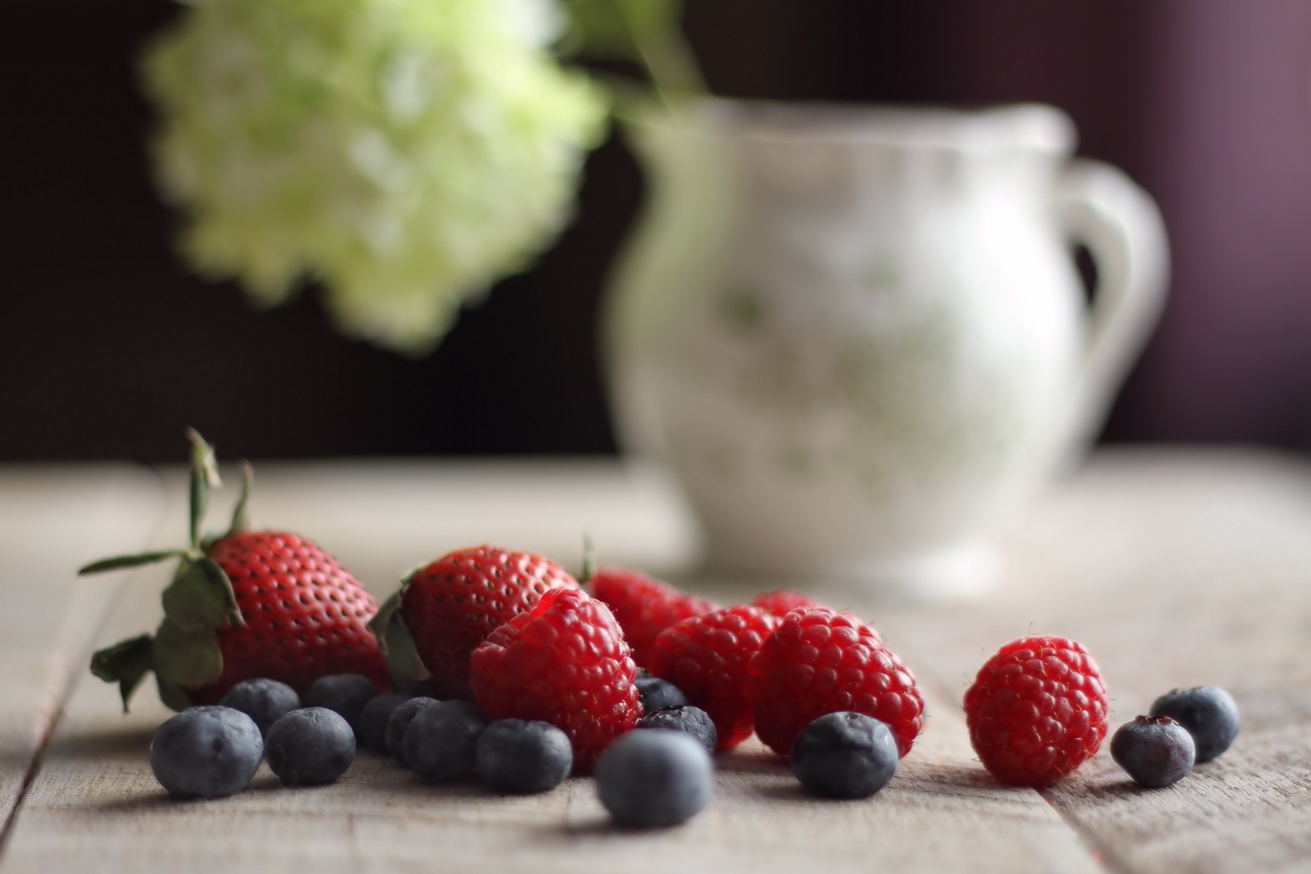 Berries and flower in a pitcher HD Wallpaper
