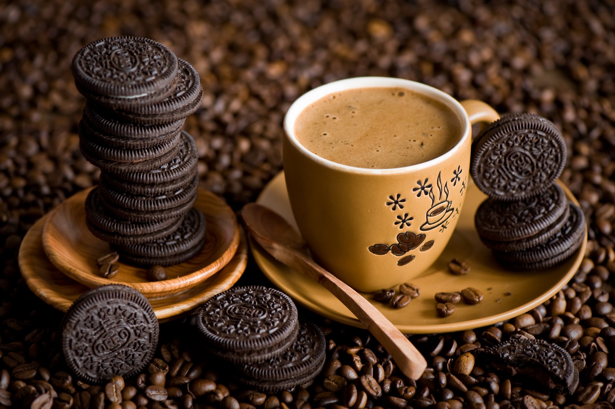 Cup of coffee with Oreos on coffee beans HD Wallpaper