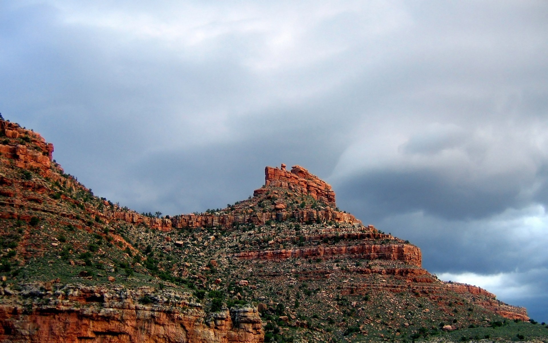 Red rock formations under a cloudy sky HD Wallpaper
