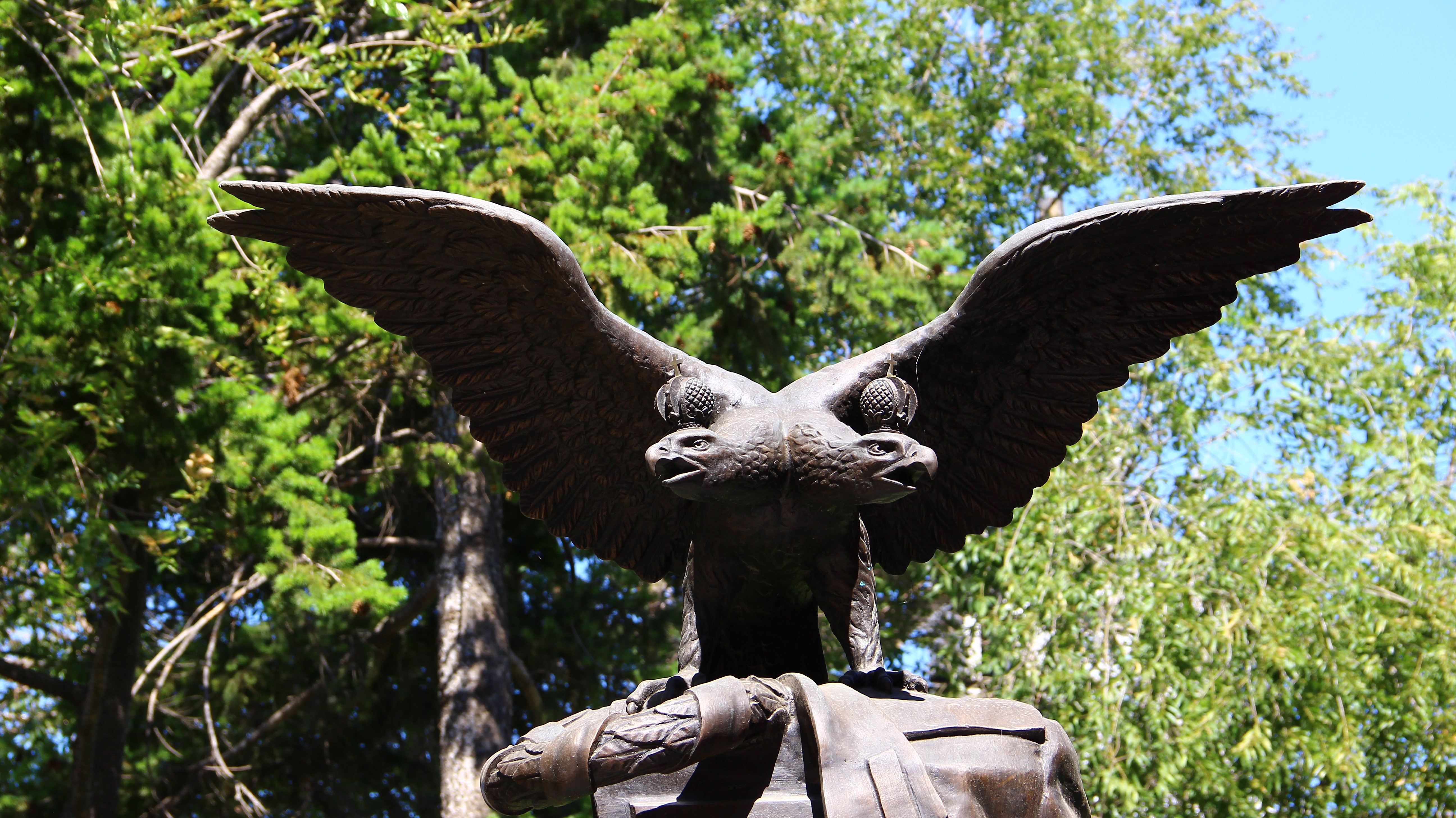 Double-headed eagle monument with trees HD Wallpaper