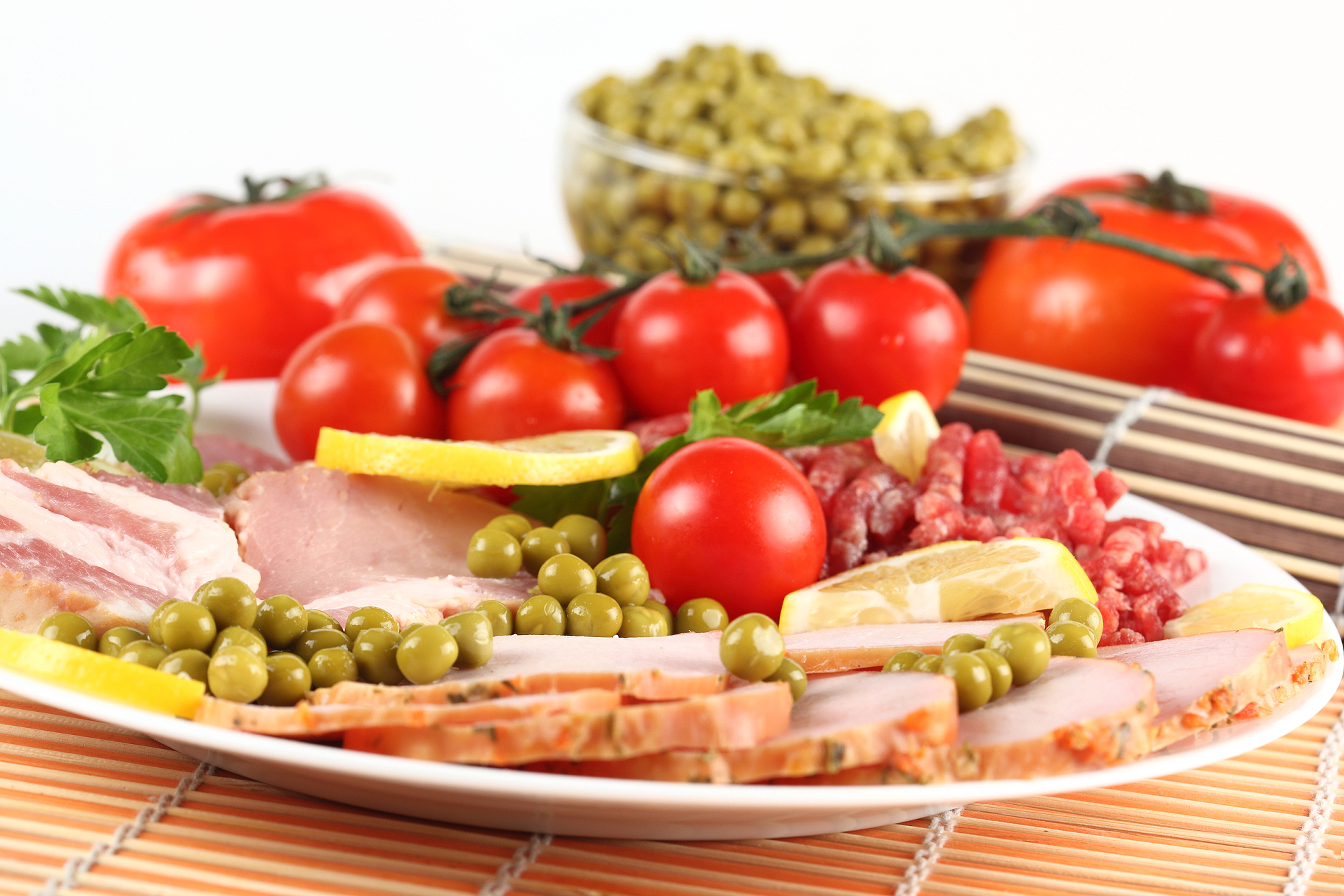 Meat platter with ham, tomatoes, peas, and lemon HD Wallpaper