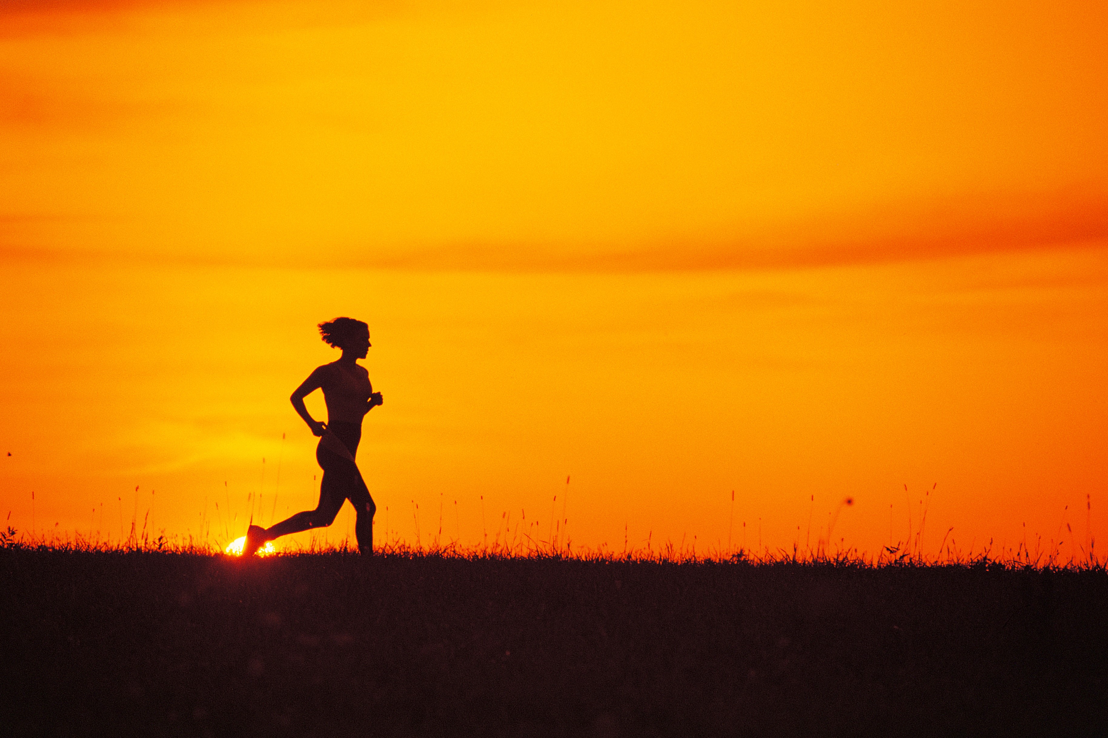 Silhouette of a woman running at sunset HD Wallpaper