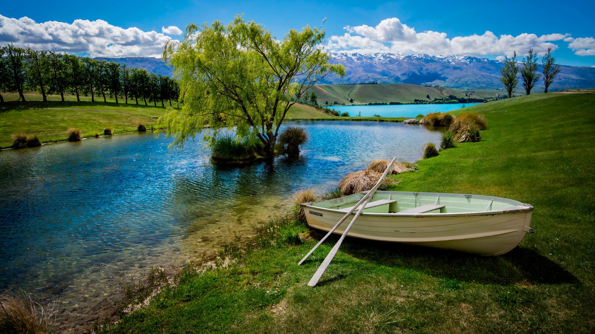 Boat and oars by a lake with mountains HD Wallpaper