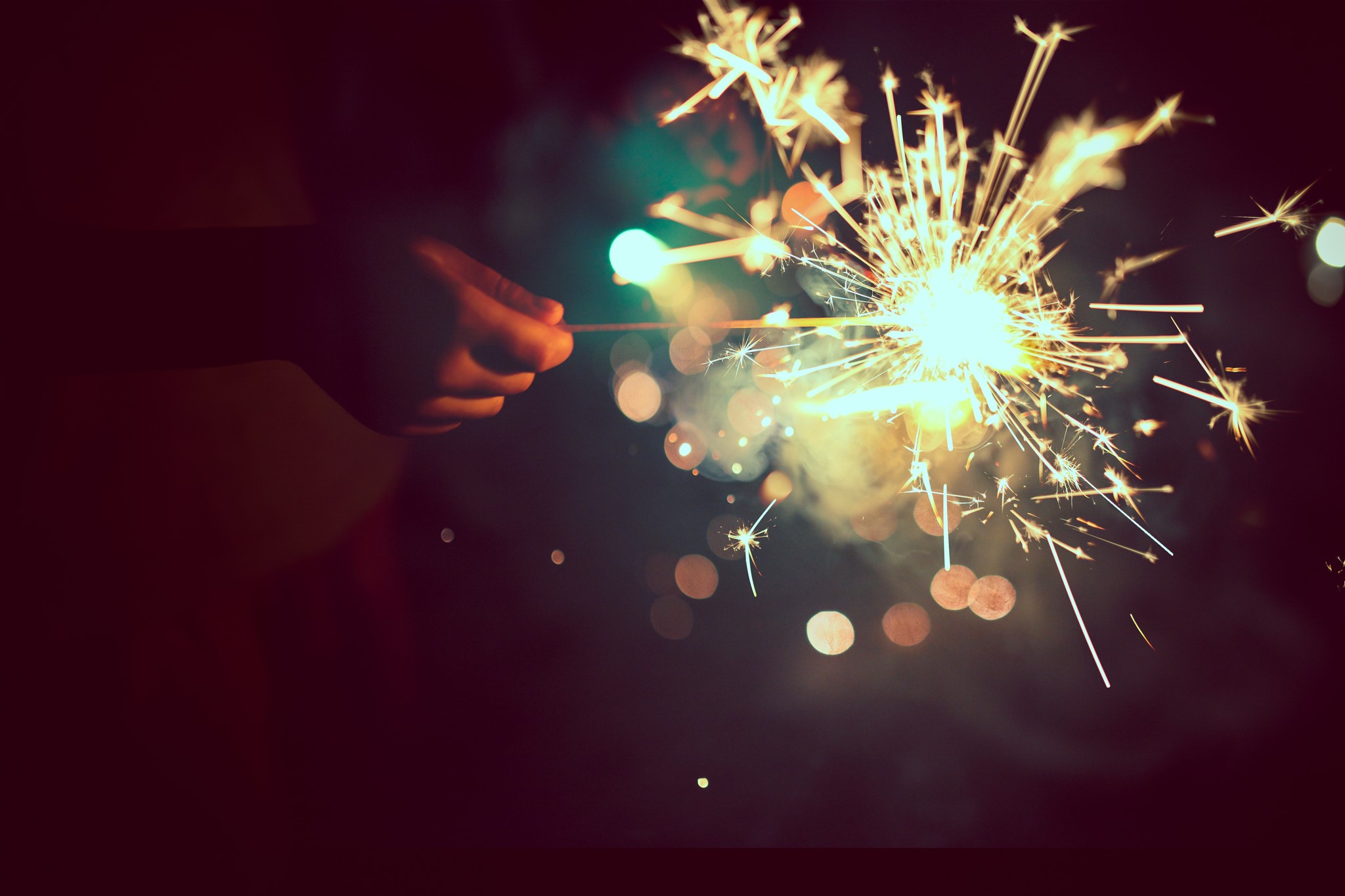 Hand holding a sparkler at night HD Wallpaper