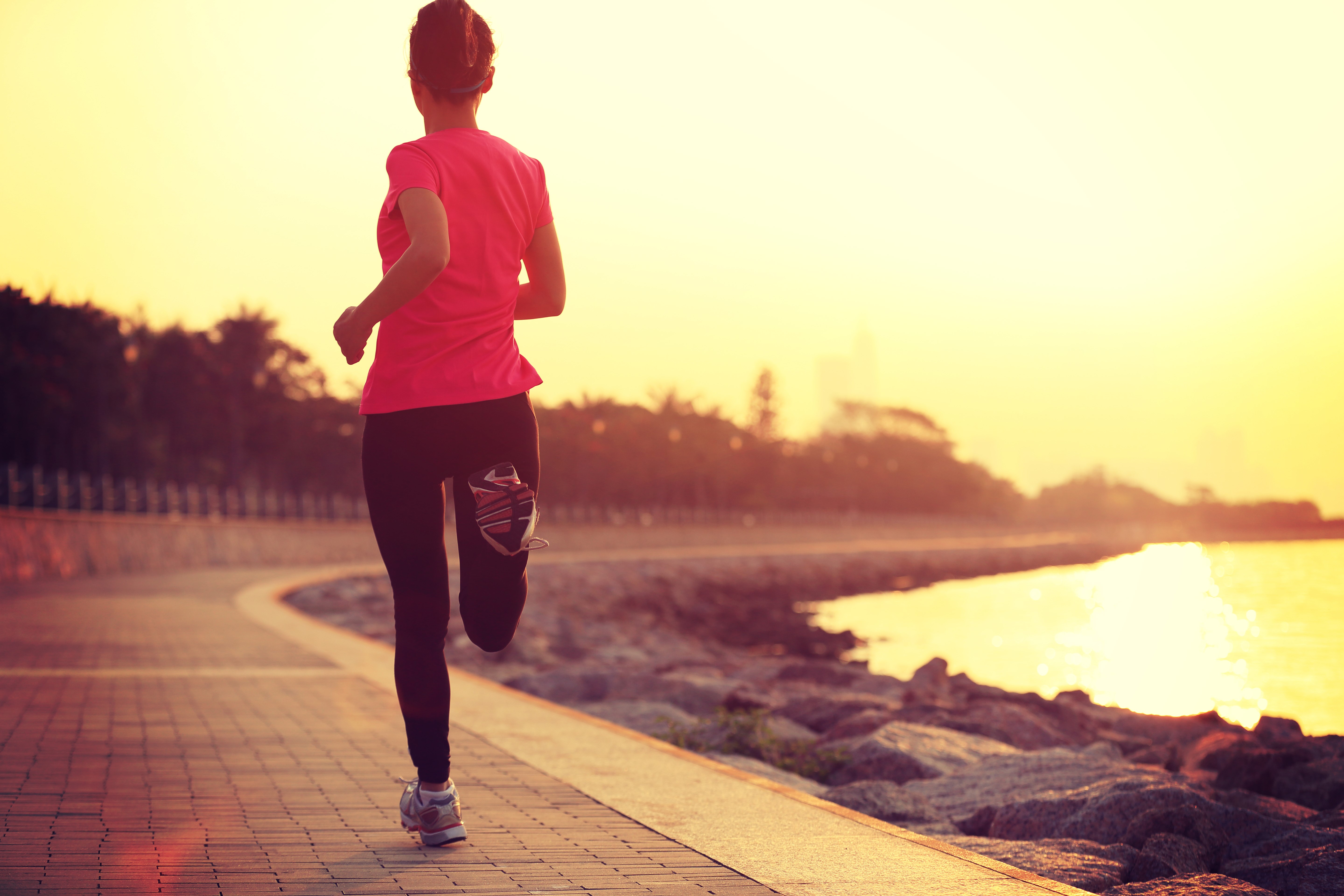 Woman running on waterfront at sunset HD Wallpaper