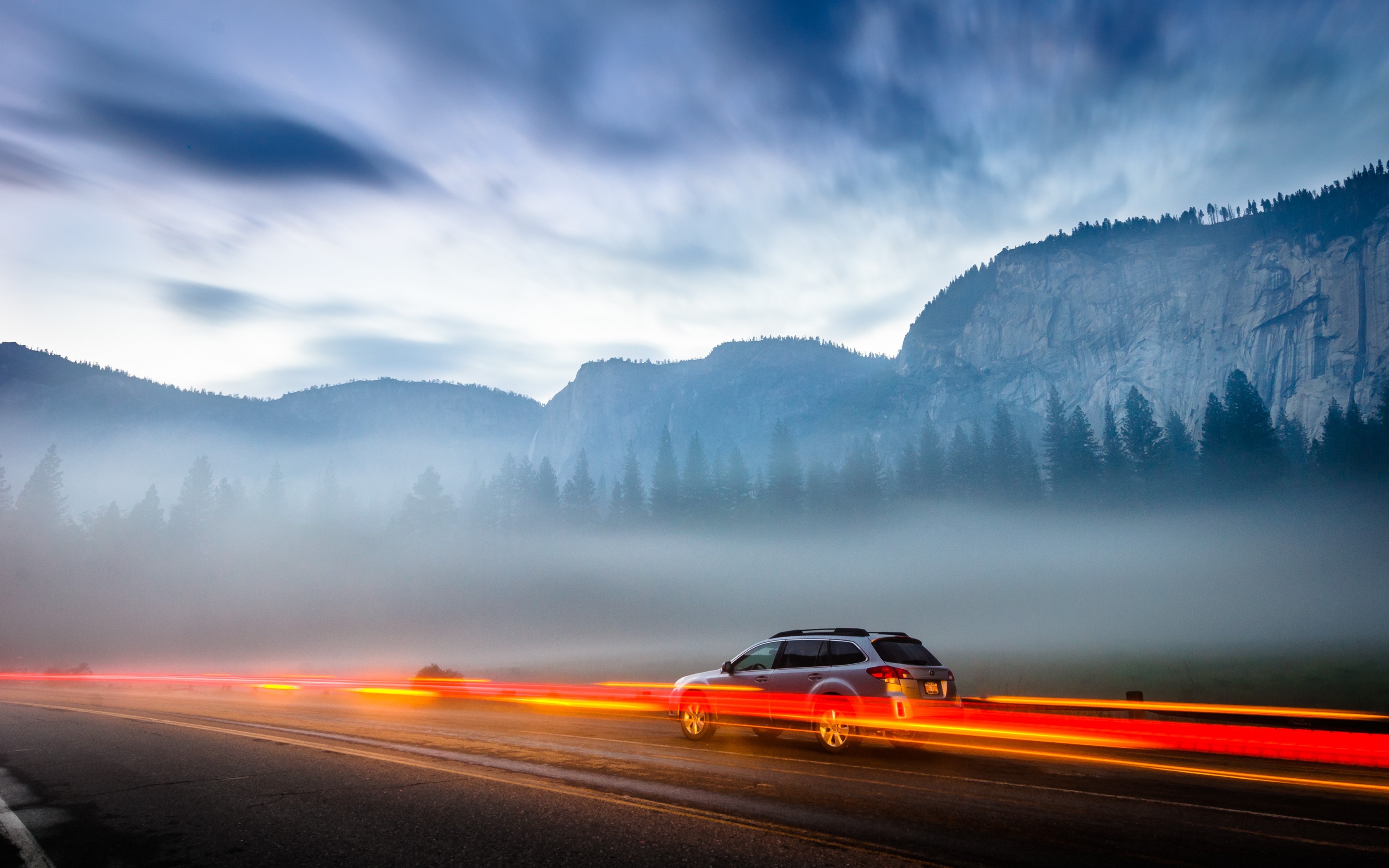 Car driving on a foggy road in Yosemite National Park HD Wallpaper