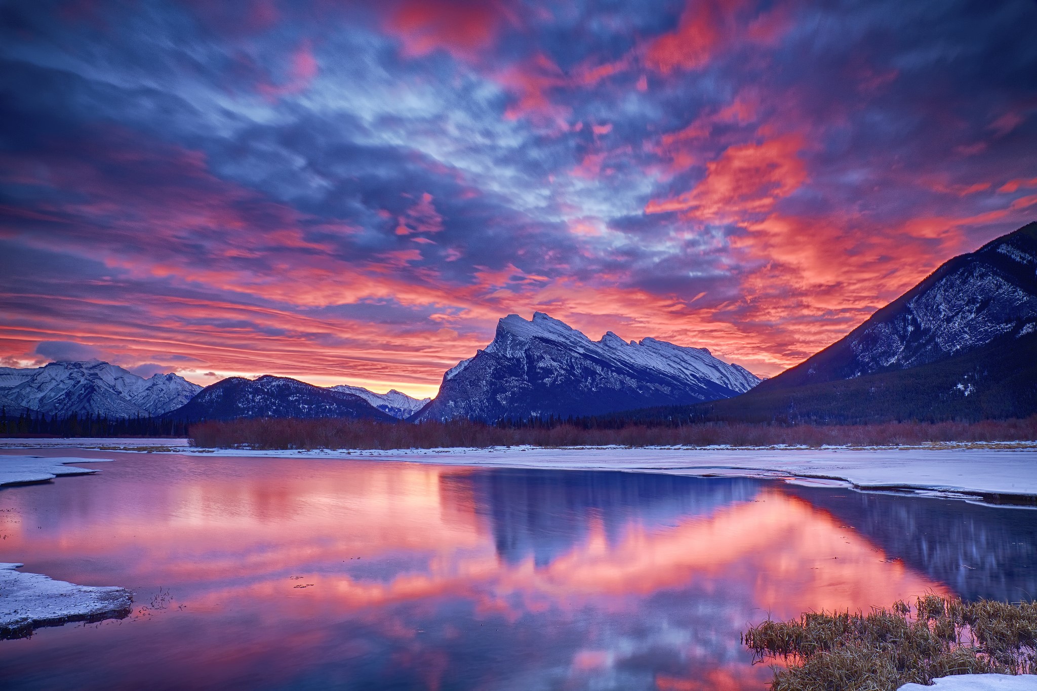 Winter sunset over a frozen lake and snow-capped mountains HD Wallpaper