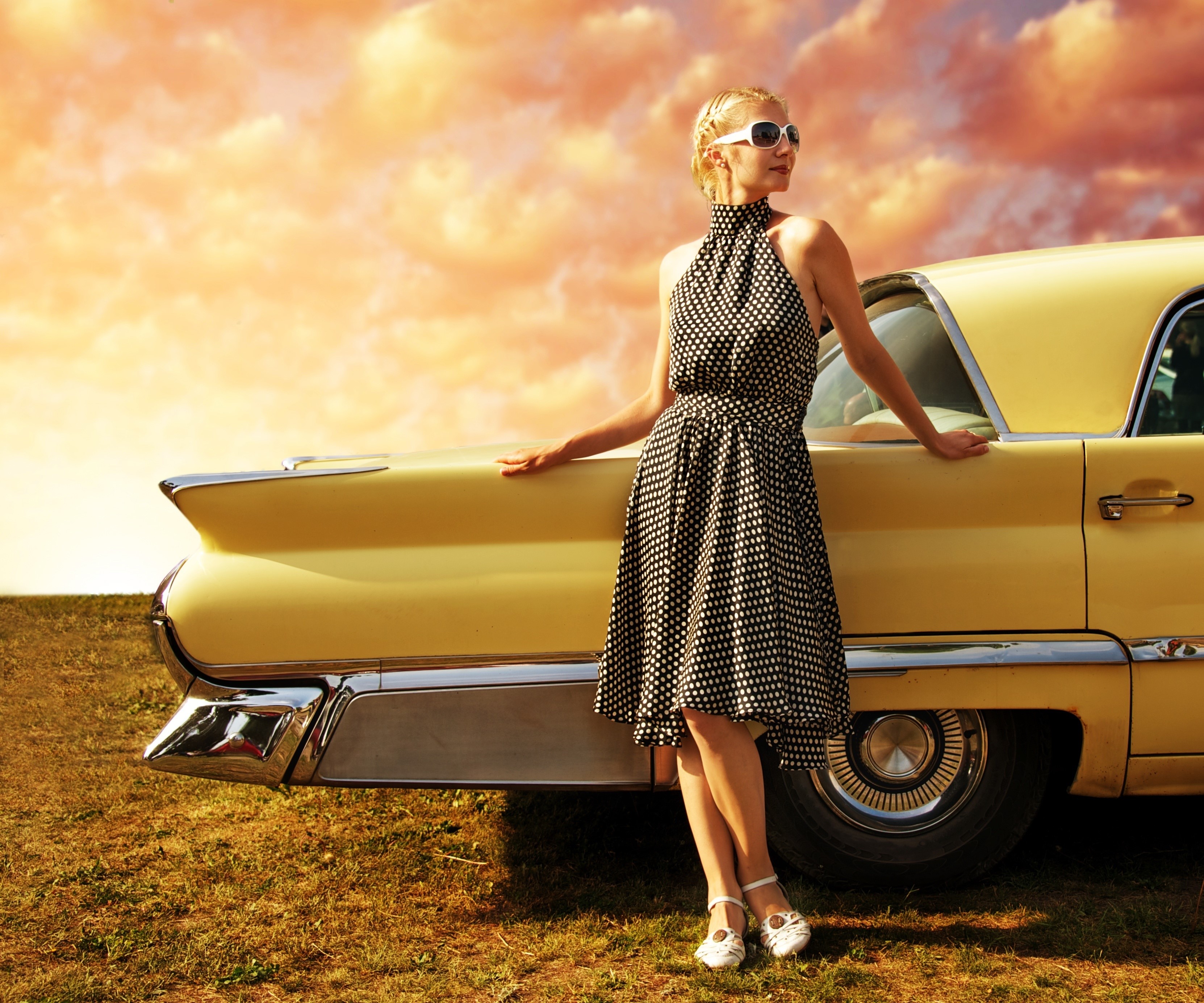 Woman in polka dot dress leaning on a yellow vintage car HD Wallpaper