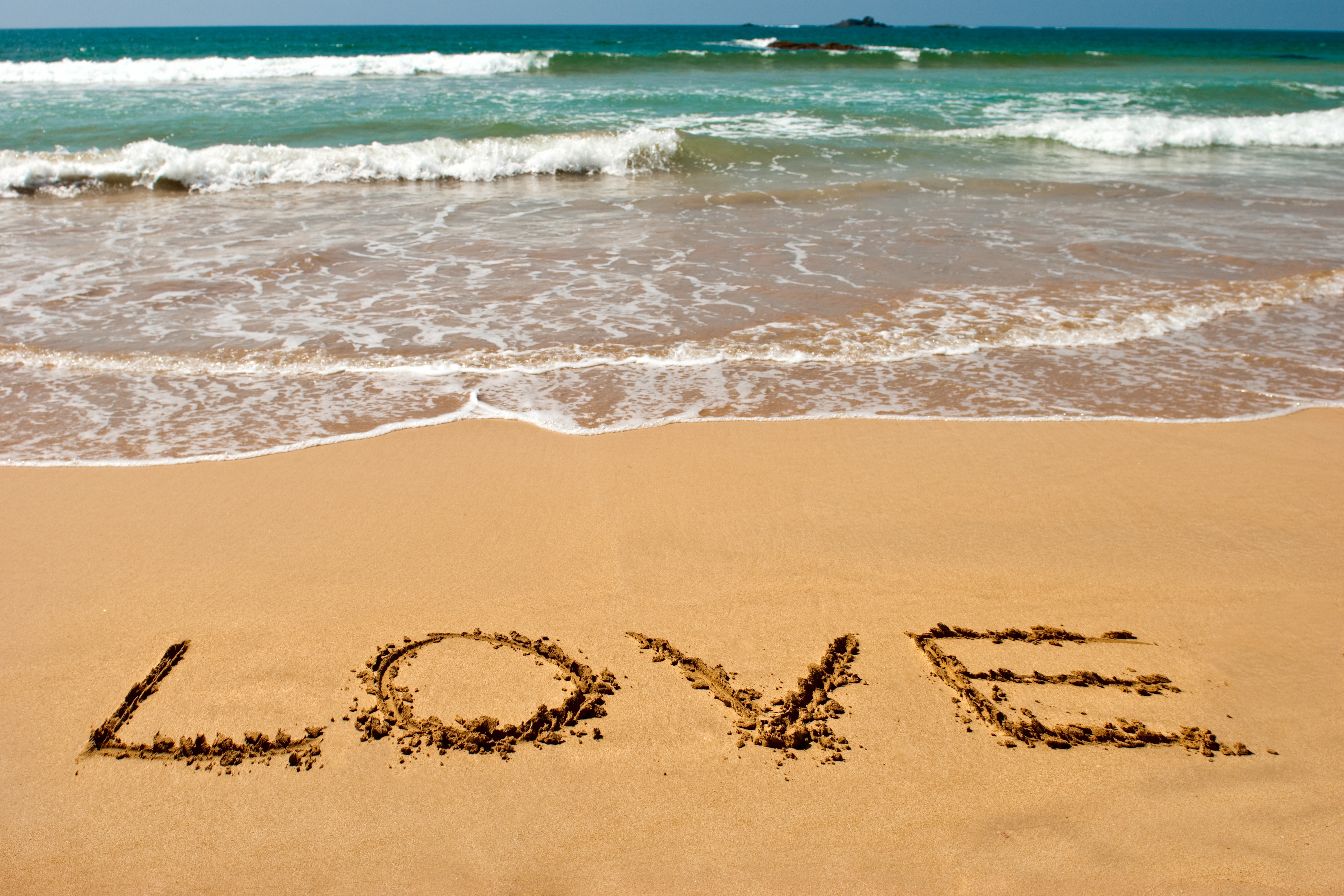 Love written in sand on a beach with waves HD Wallpaper