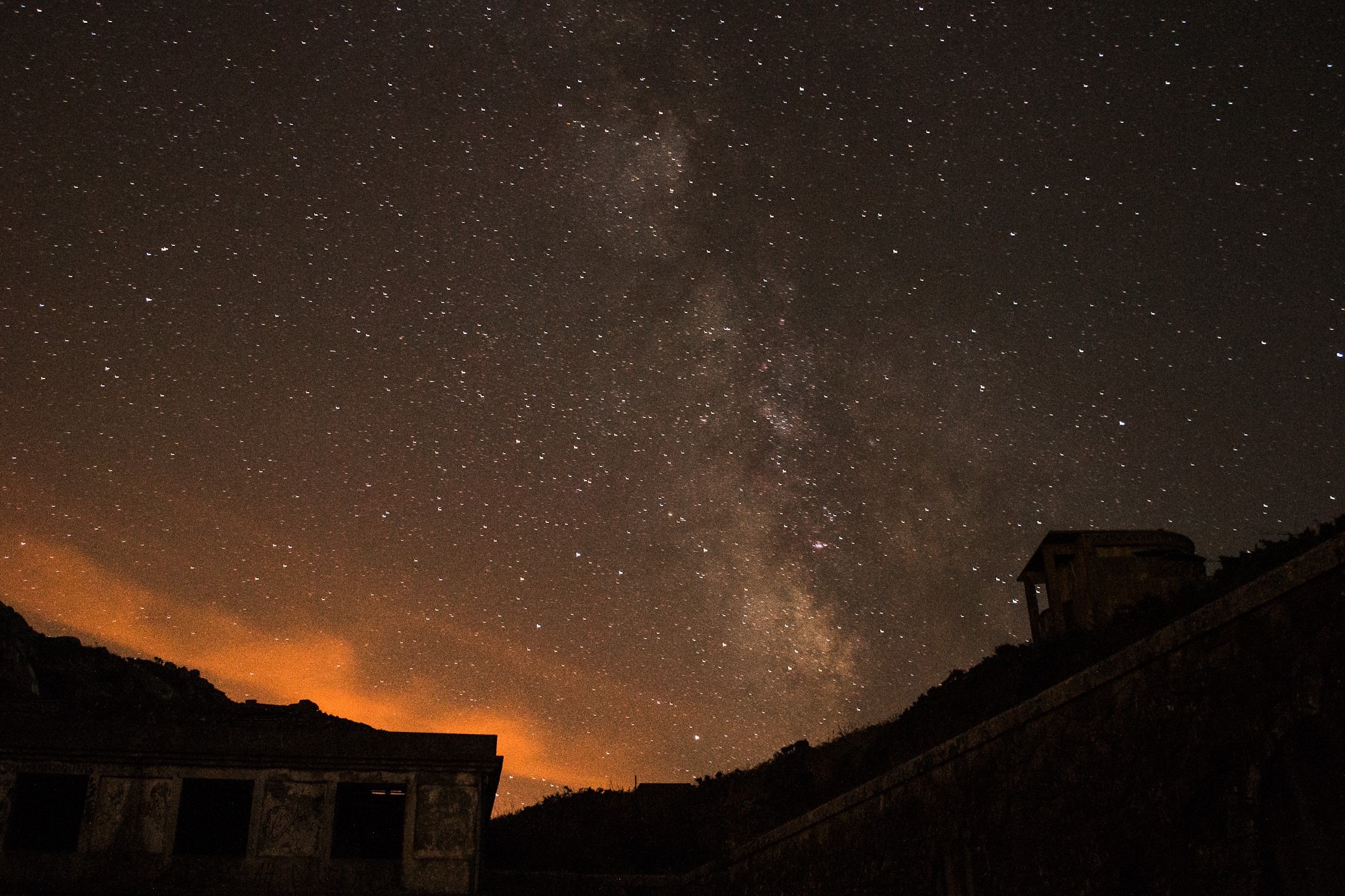 Milky Way and abandoned buildings under the night sky HD Wallpaper