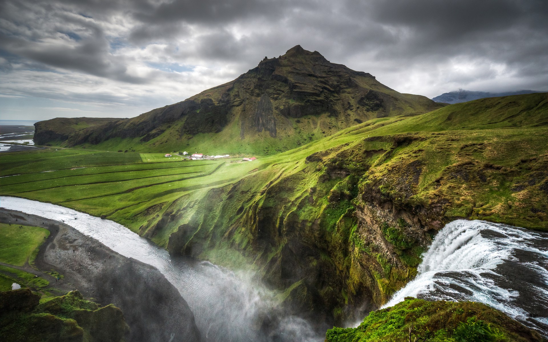 Waterfall cascading over green cliffs in Iceland HD Wallpaper