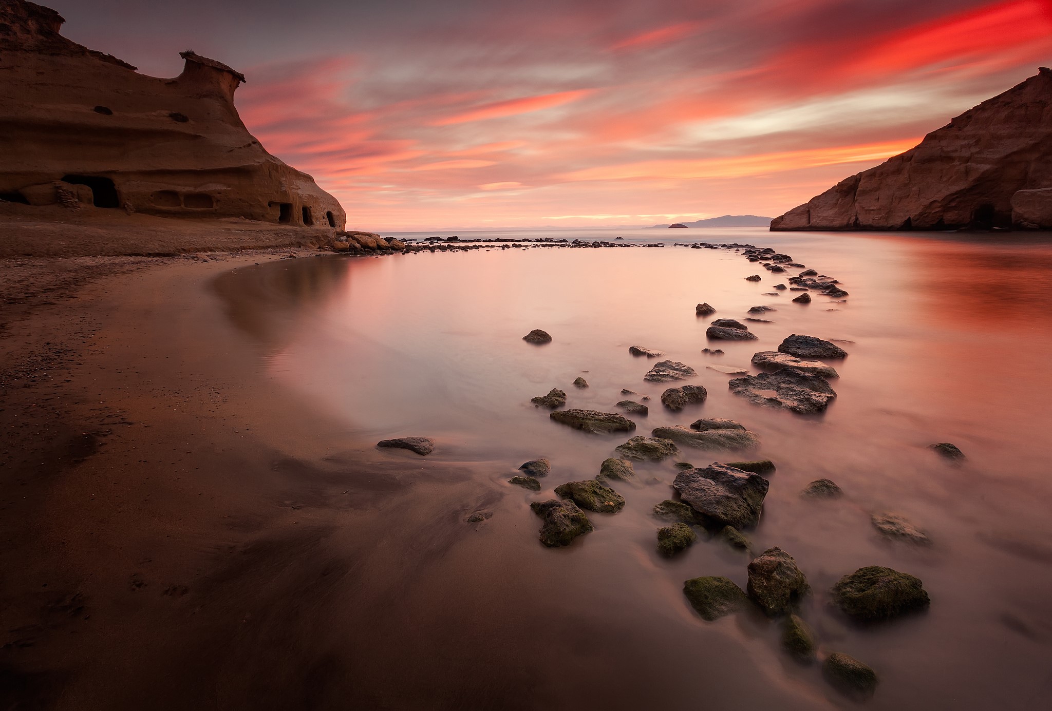 Rocky coast with caves and sunset over the sea HD Wallpaper
