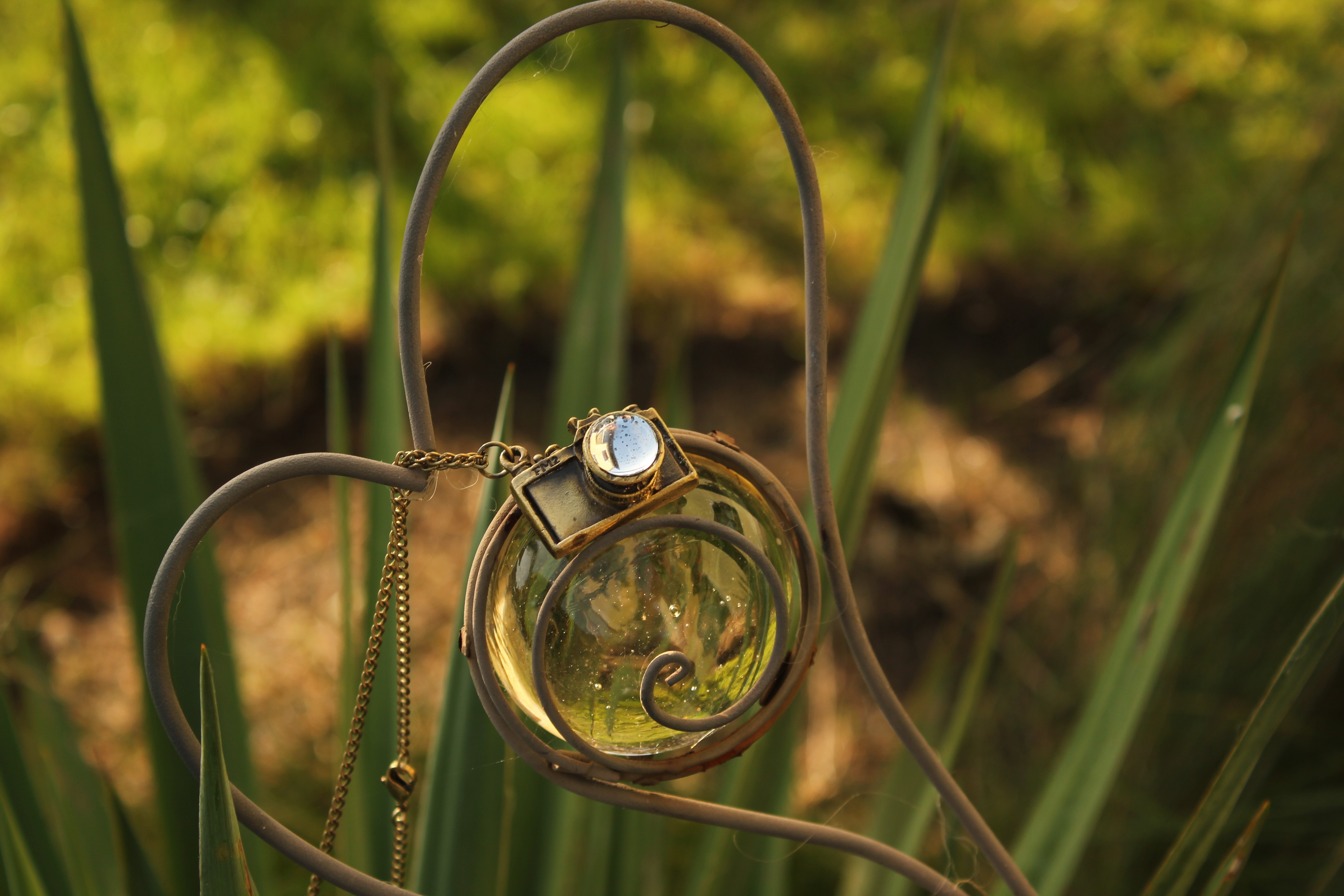 Close-up of a camera pendant on a decorative garden ornament HD Wallpaper