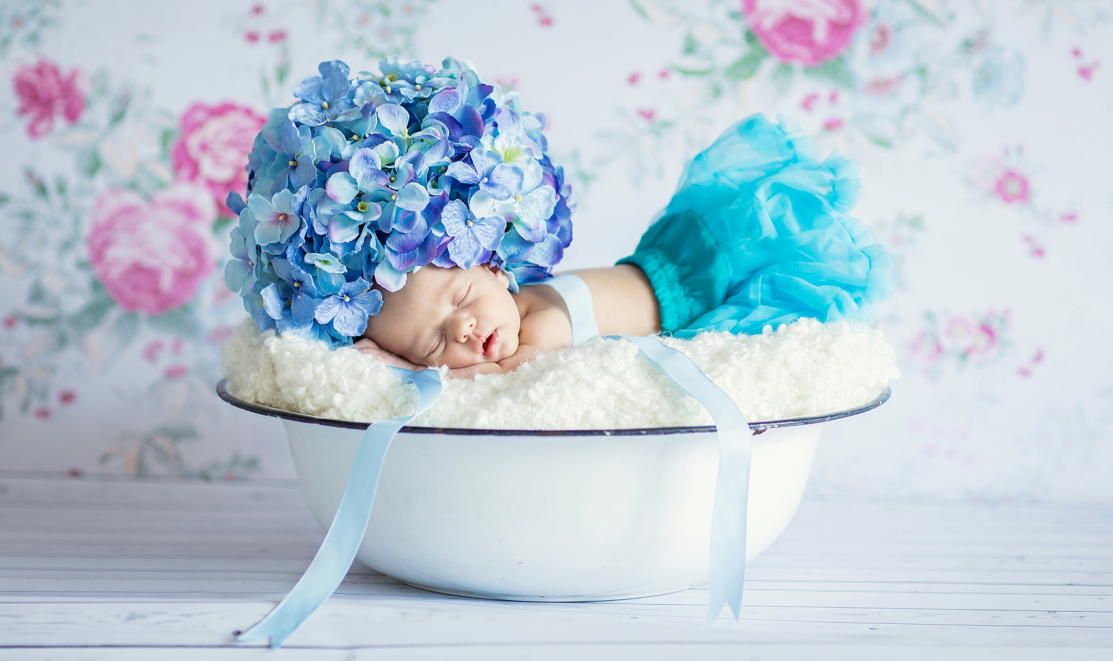 Baby sleeping in a bowl with hydrangea hat HD Wallpaper