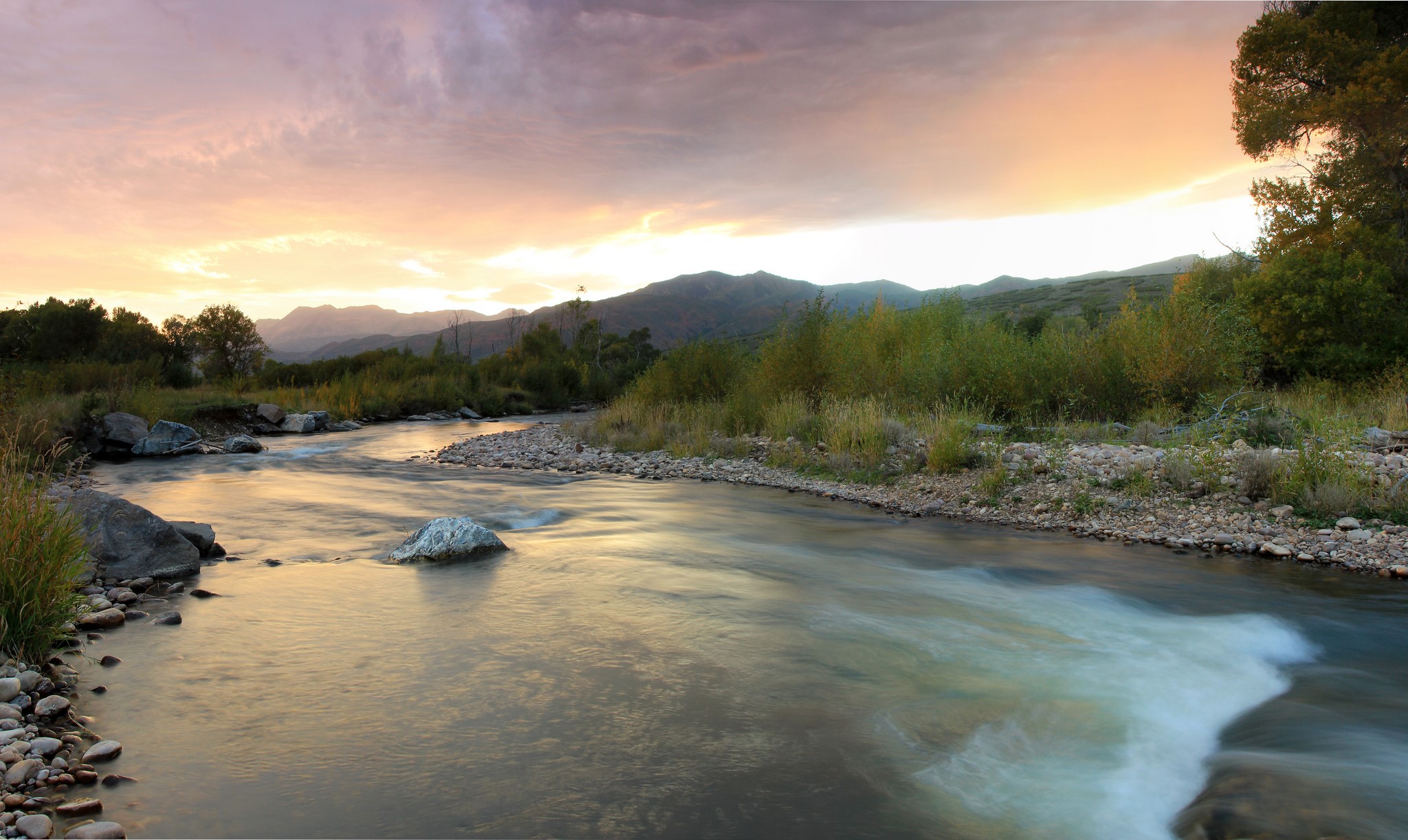 River flowing through mountains at sunset HD Wallpaper