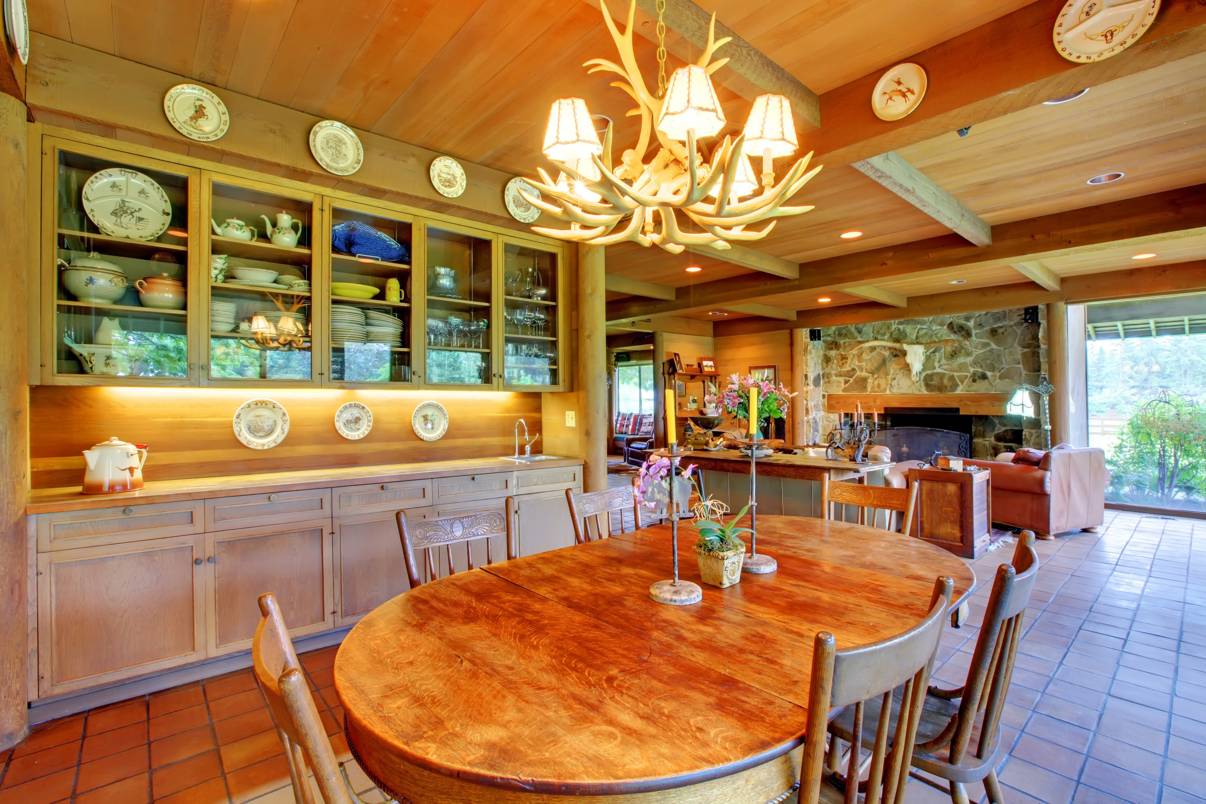 Rustic Dining Room with Antler Chandelier and Stone Fireplace HD Wallpaper