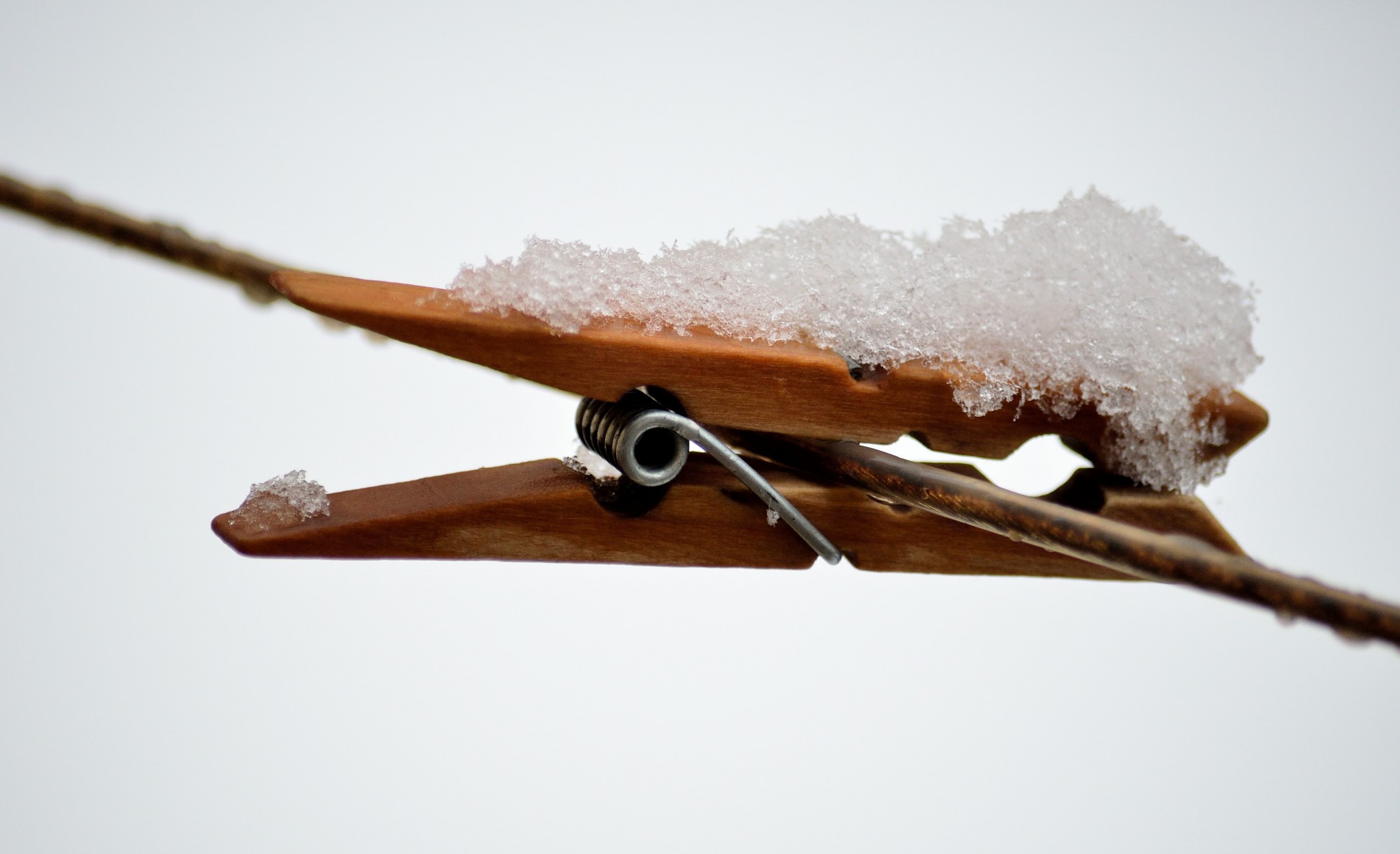 Wooden clothespin with snow on a wire HD Wallpaper