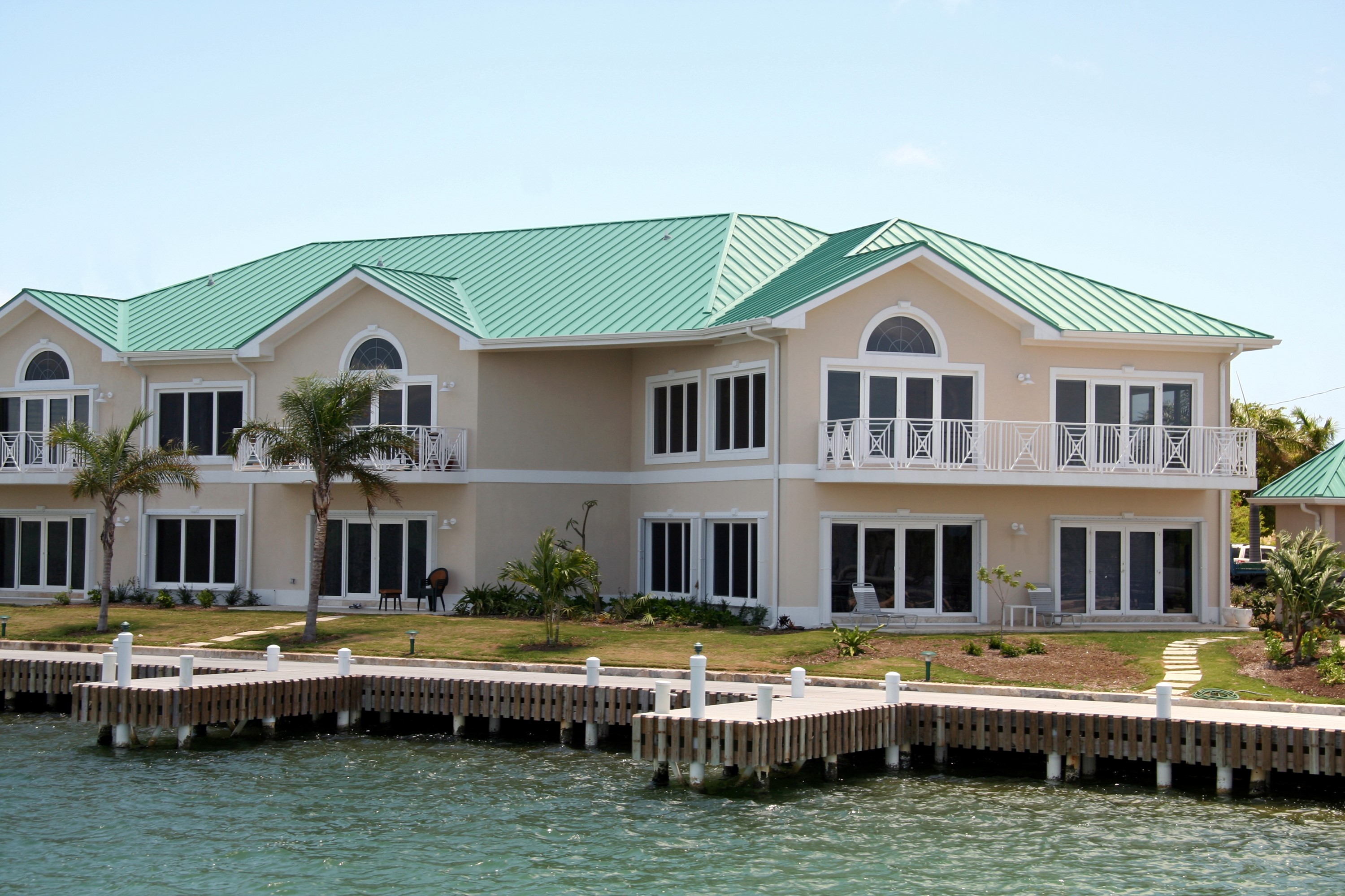 Waterfront houses with green roofs and a wooden dock HD Wallpaper