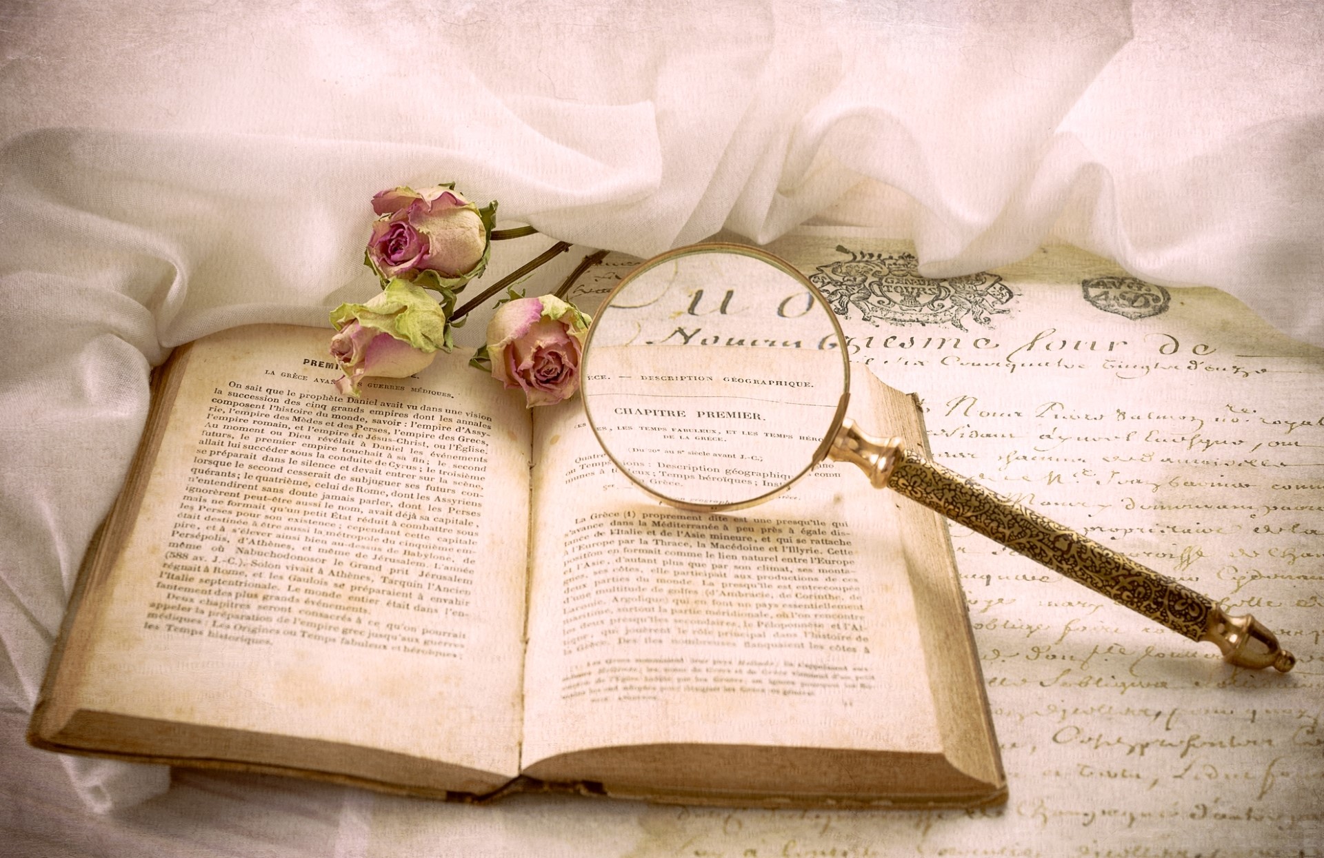 Open book with magnifying glass and dried roses HD Wallpaper