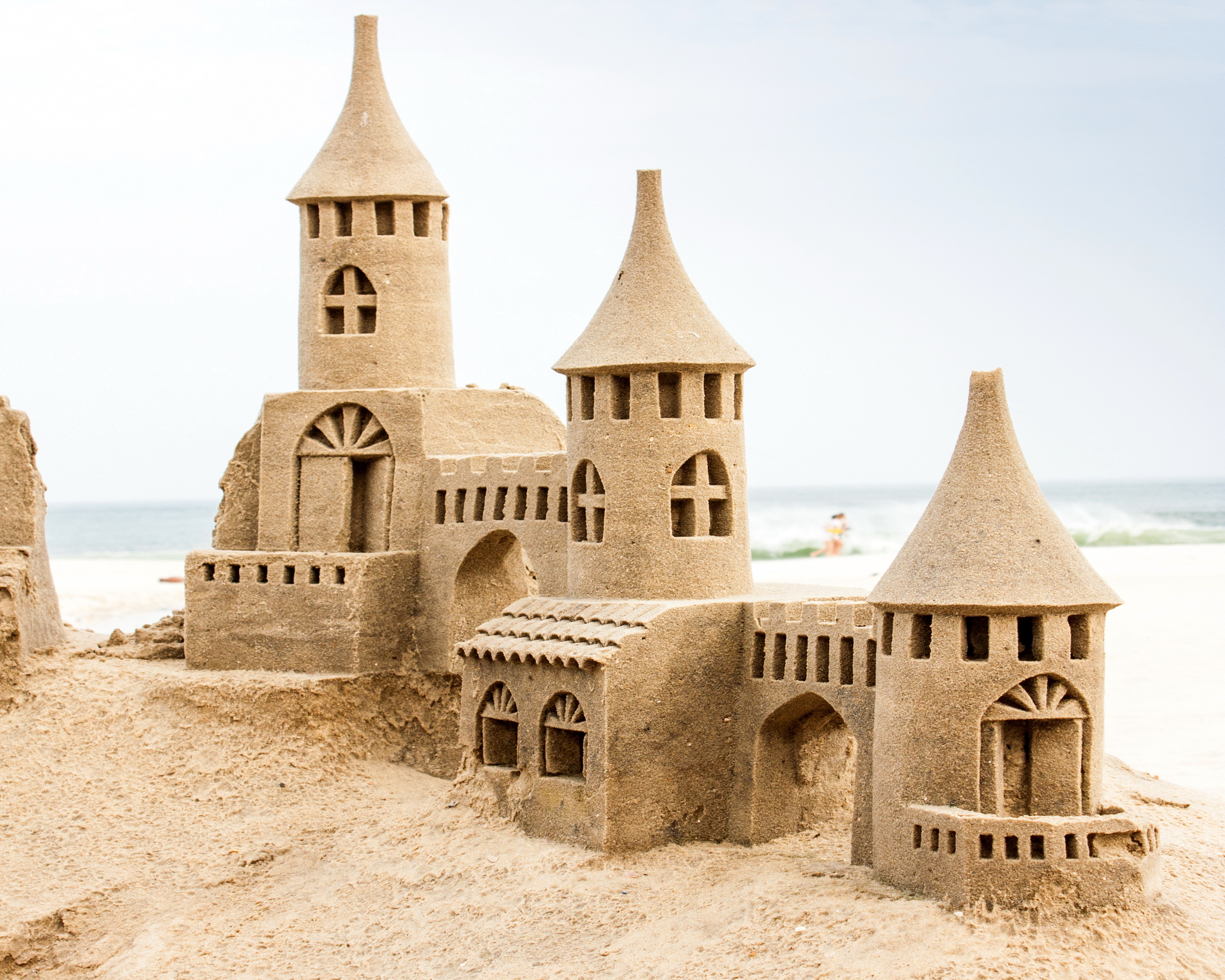 Sandcastle on a beach with the ocean in the background HD Wallpaper