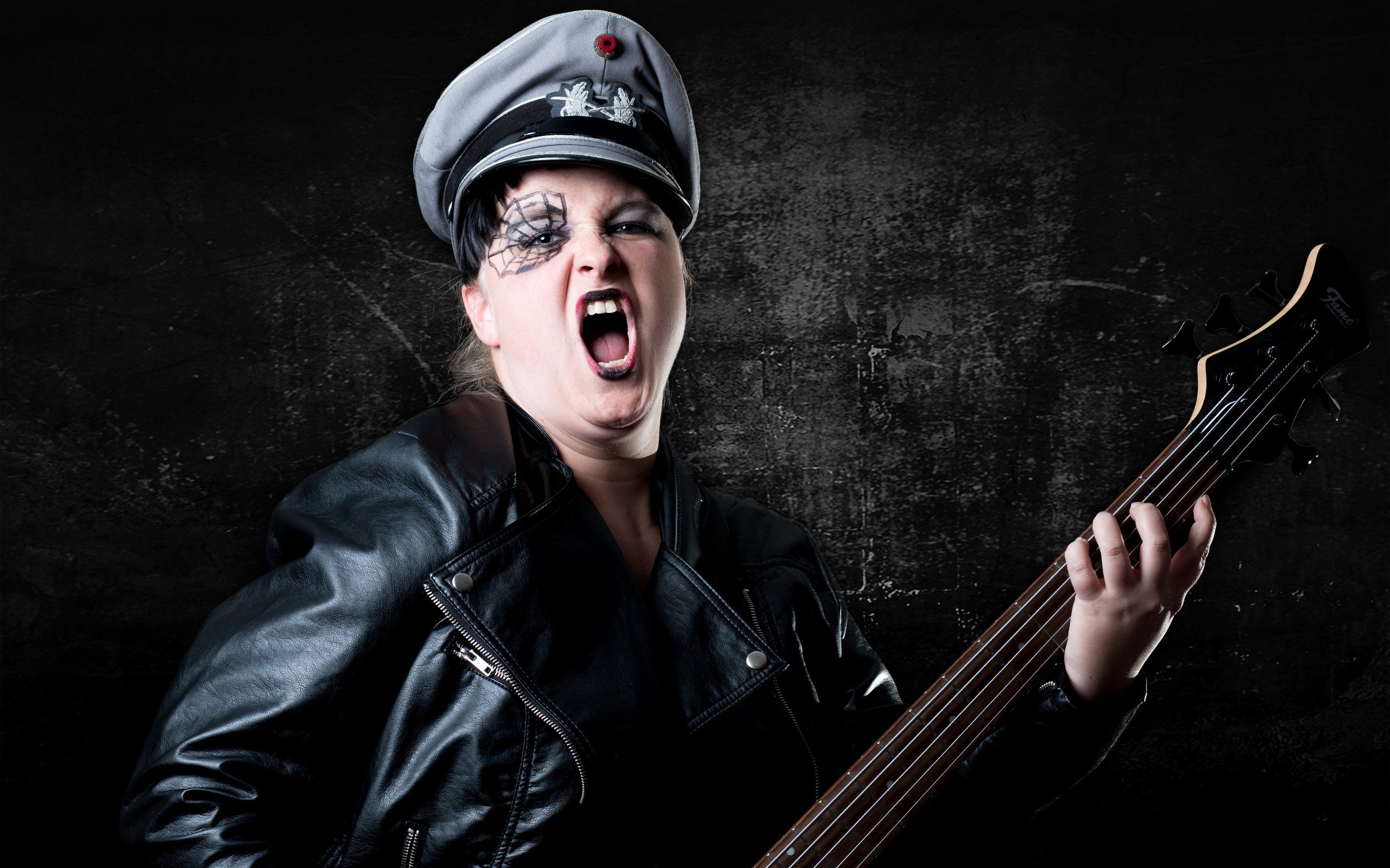 Woman in leather jacket and hat playing bass guitar HD Wallpaper