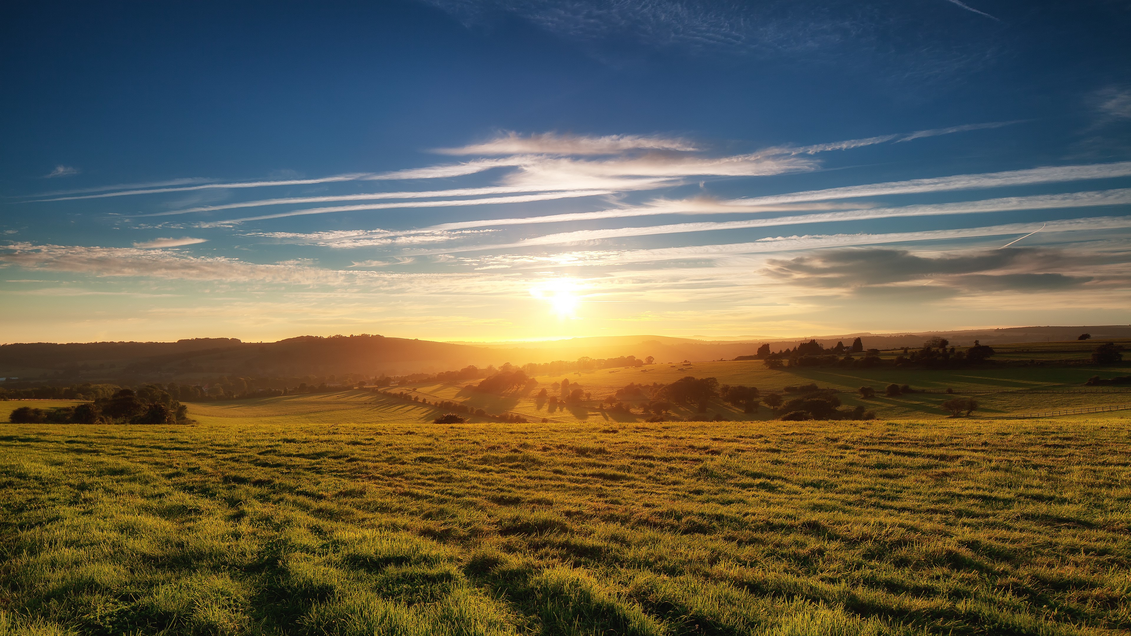 Sunrise over rolling green fields and hills HD Wallpaper