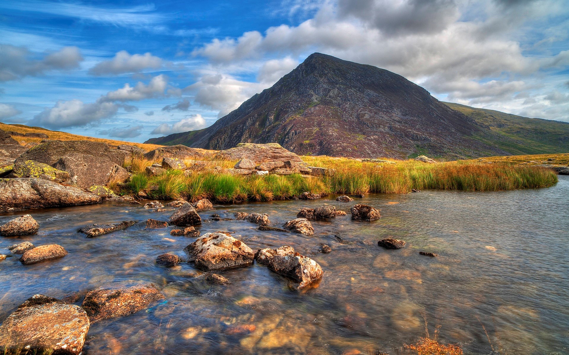 Mountain landscape with stream and rocky terrain HD Wallpaper
