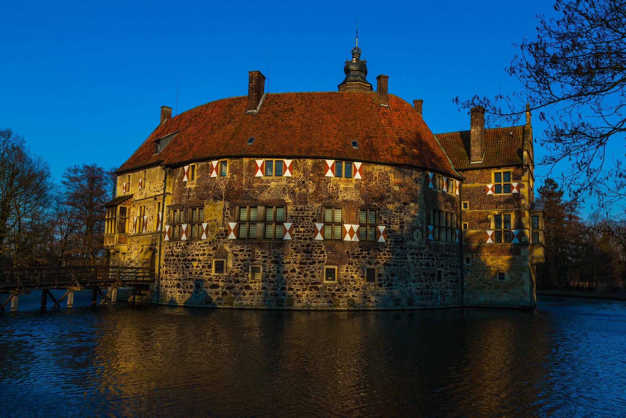Castle surrounded by water under a blue sky HD Wallpaper