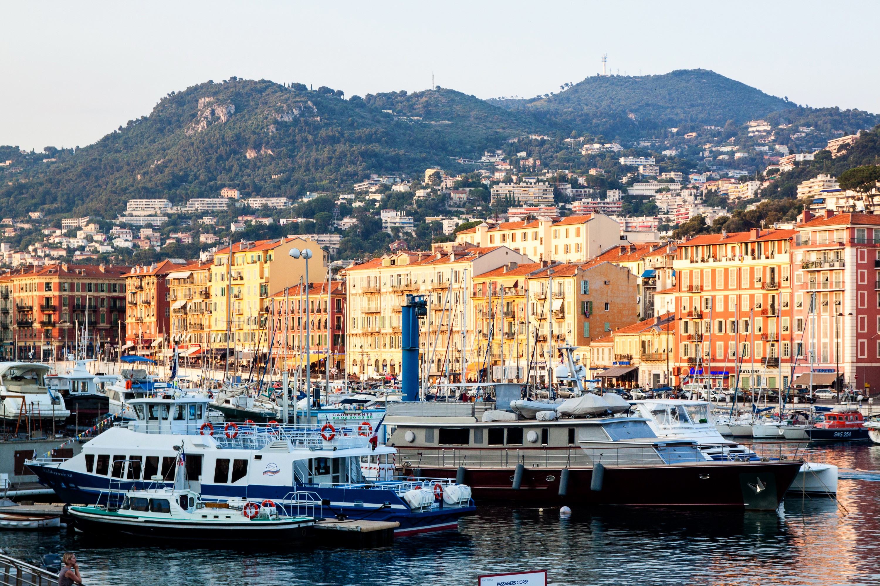 Boats docked in a harbor with buildings and mountains in Nice, France HD Wallpaper