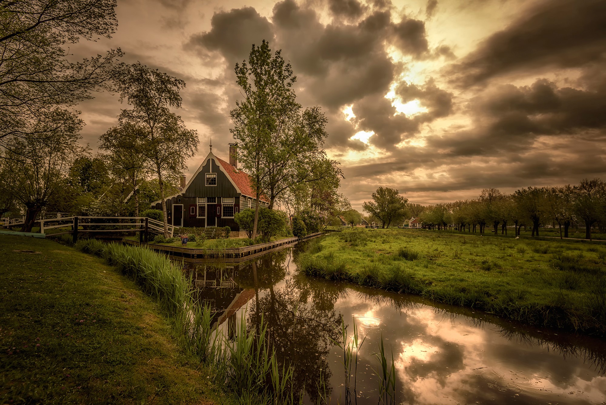A Dutch house by a canal under a cloudy sky HD Wallpaper