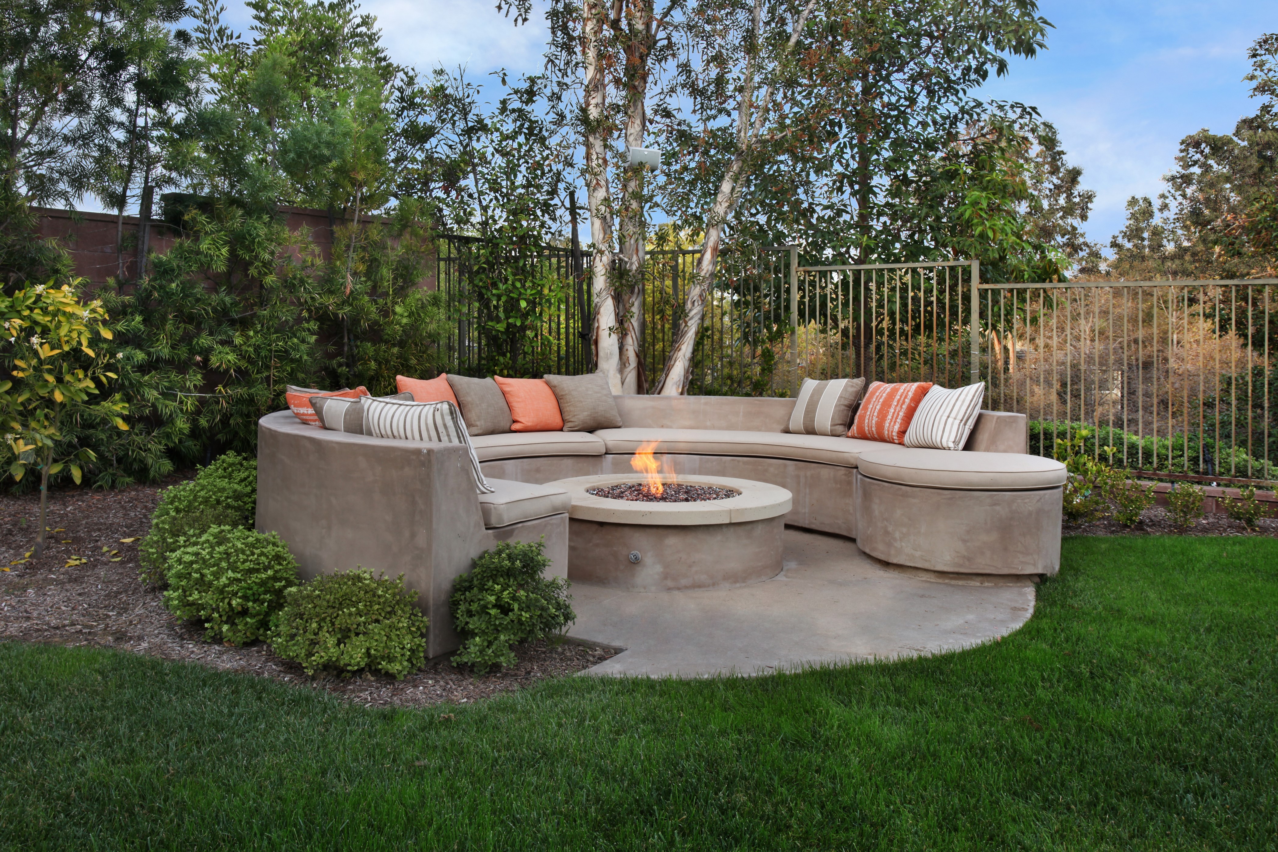 Outdoor curved sofa with fire pit and pillows HD Wallpaper