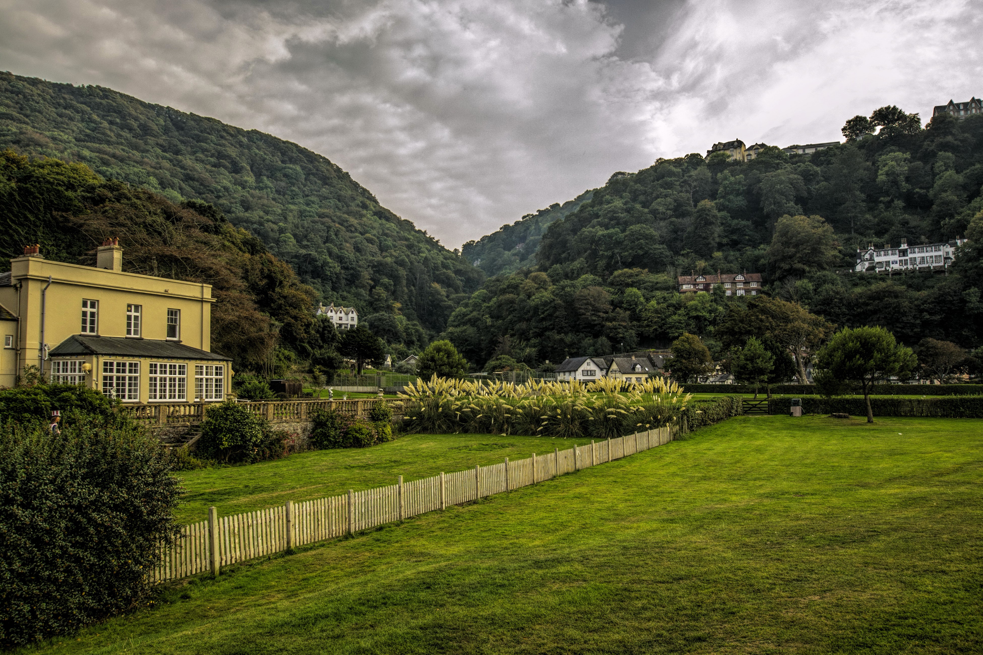 Houses on forested hillsides in Lynmouth, England HD Wallpaper