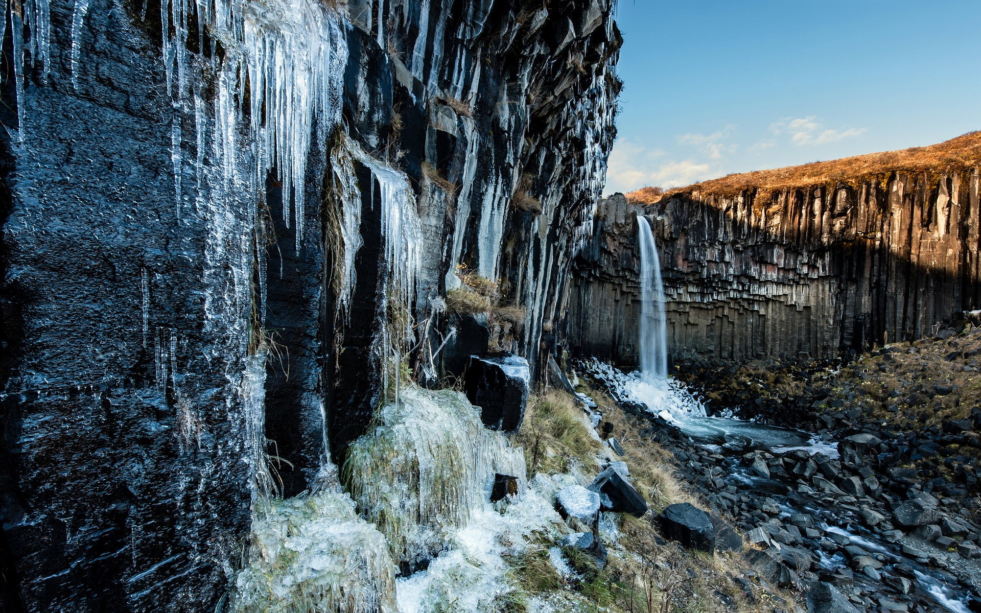 Frozen waterfall cascading over basalt columns HD Wallpaper
