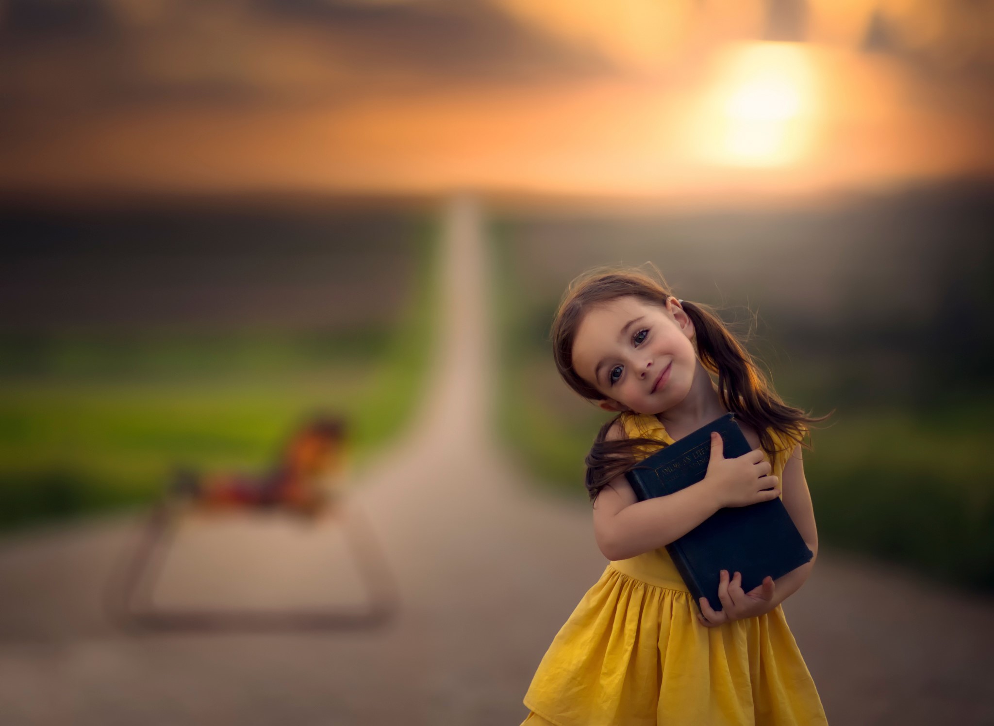 Girl holding a book on a road at sunset HD Wallpaper