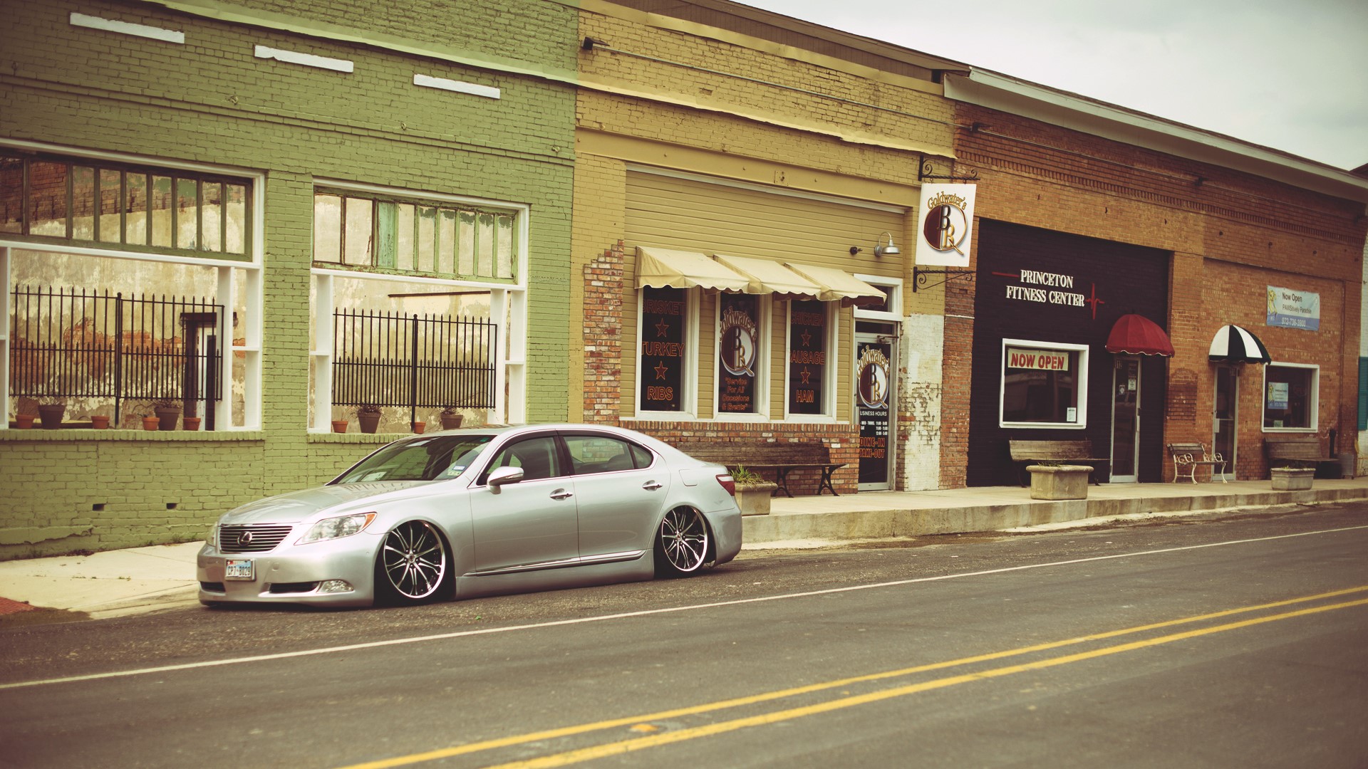 Silver Lexus LS600 parked on a street in front of shops HD Wallpaper