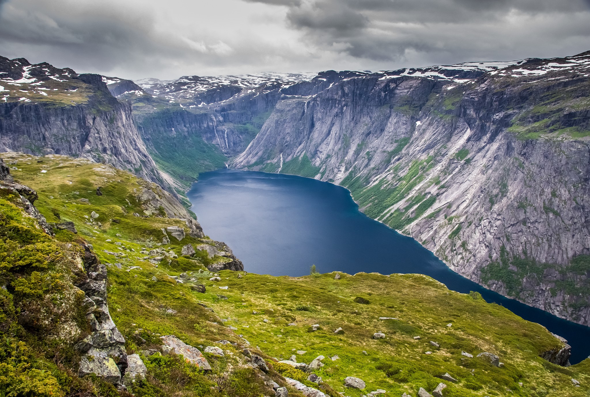 Deep blue lake surrounded by steep, rocky mountains HD Wallpaper