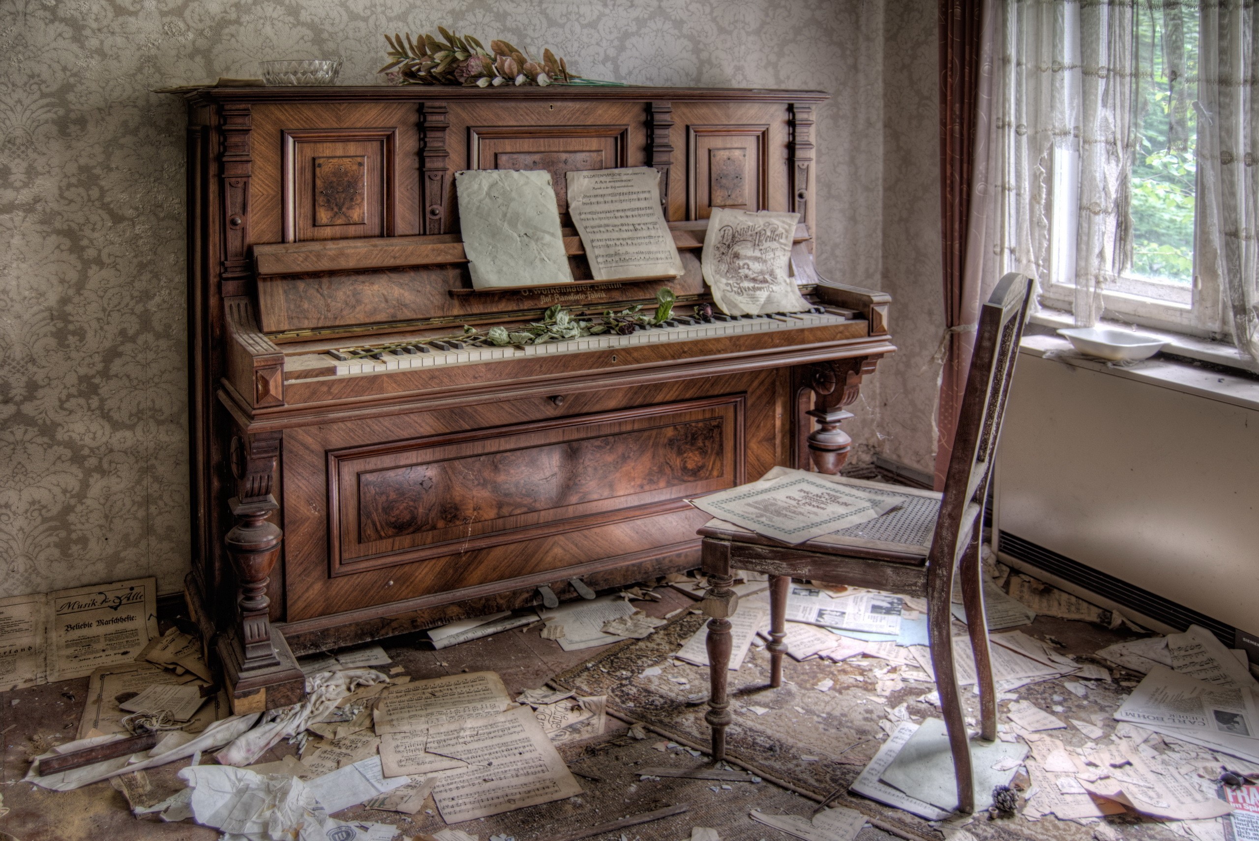 Abandoned piano and chair with scattered sheet music HD Wallpaper