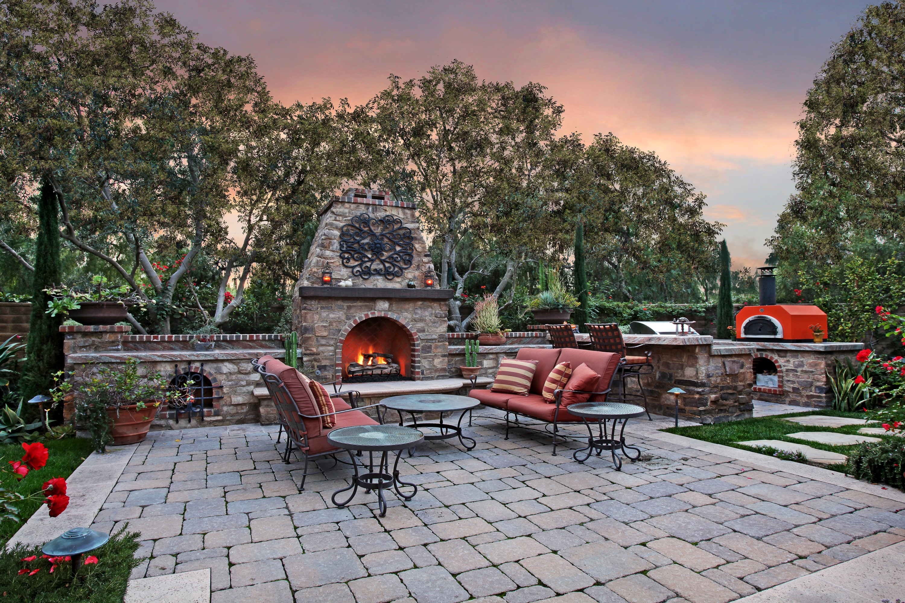 Outdoor patio with fireplace, seating, and pizza oven HD Wallpaper